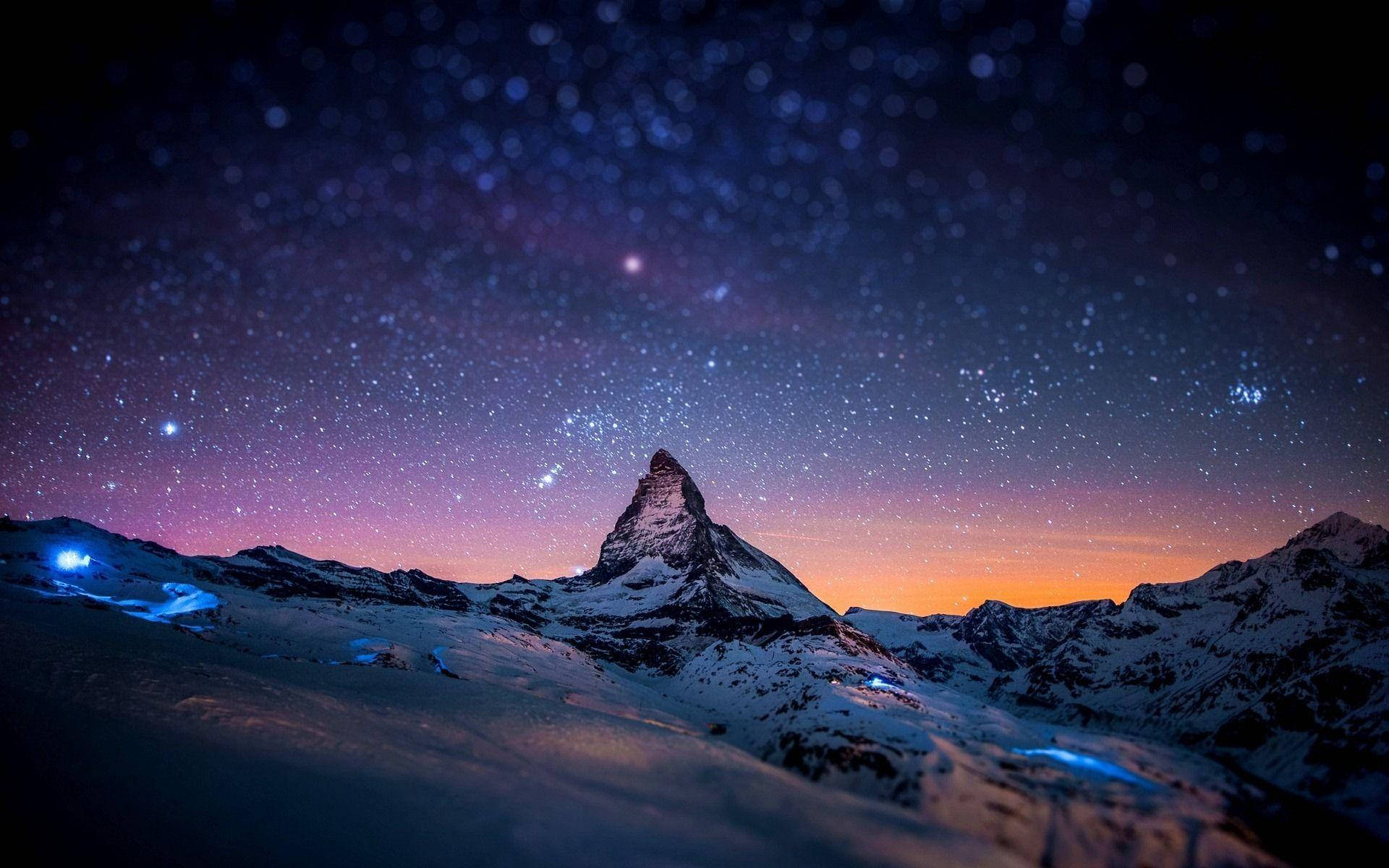 A Mountain With Stars Above It At Night Background