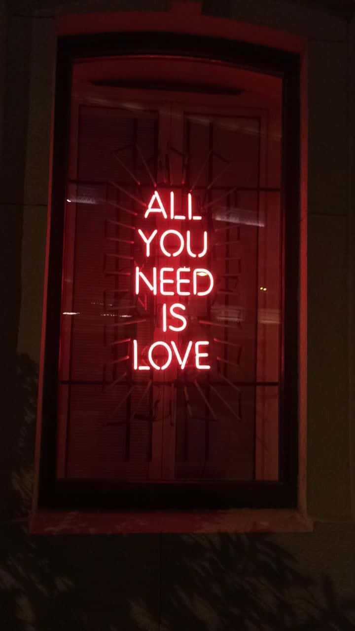 A Neon Sign That Says All You Need Is Love Background