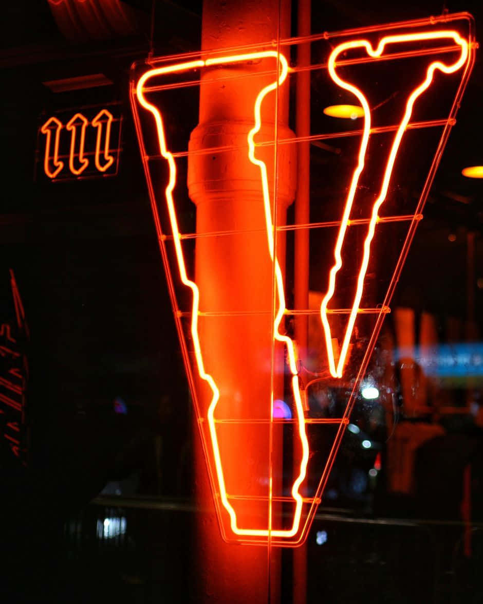 A Neon Sign With A Letter V Background