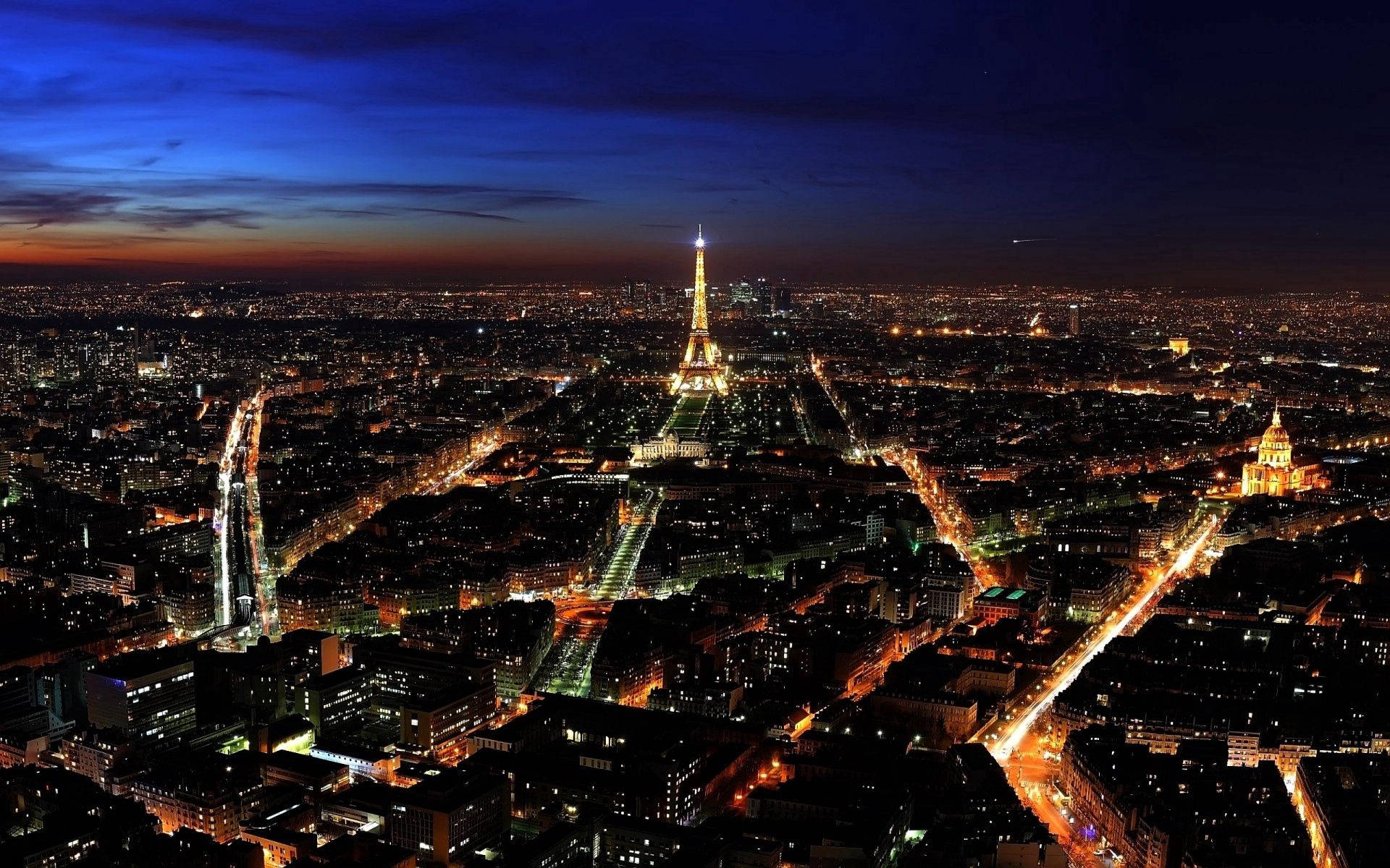 “a Nighttime View Of The City Of Lights” Background