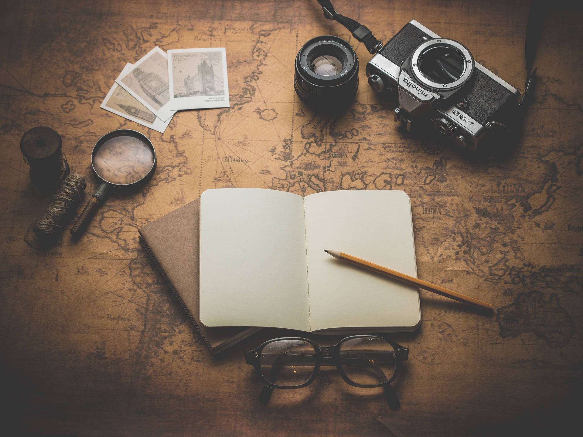 A Notebook, Camera, Magnifying Glass And Map On A Wooden Table Background