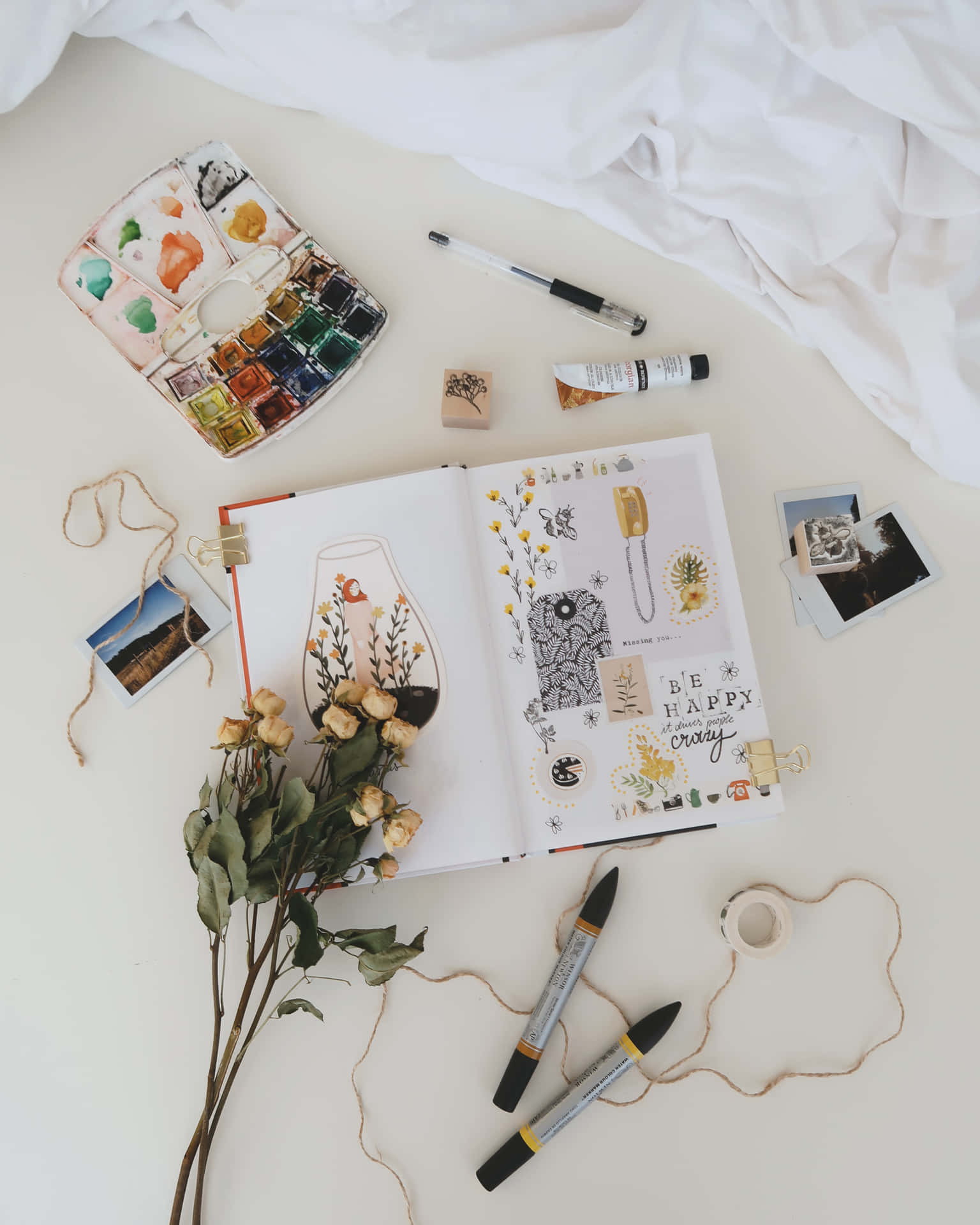 A Notebook, Flowers, And Other Items Are Laid Out On A Bed Background