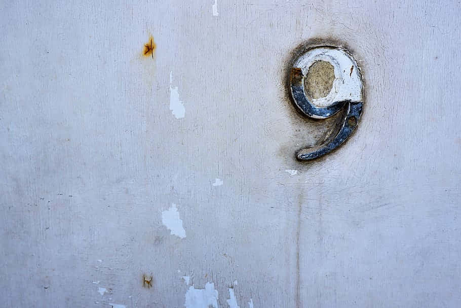 A Number Nine On A White Wall Background