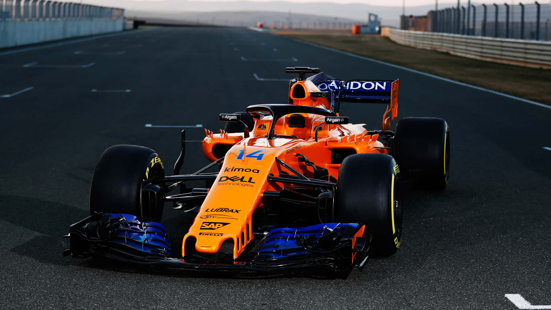 A Orange Racing Car Is Driving Down A Track Background