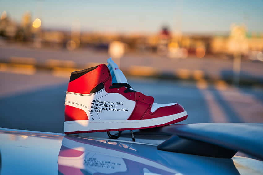 A Pair Of Air Jordan 1 High Sneakers On Top Of A Car Background