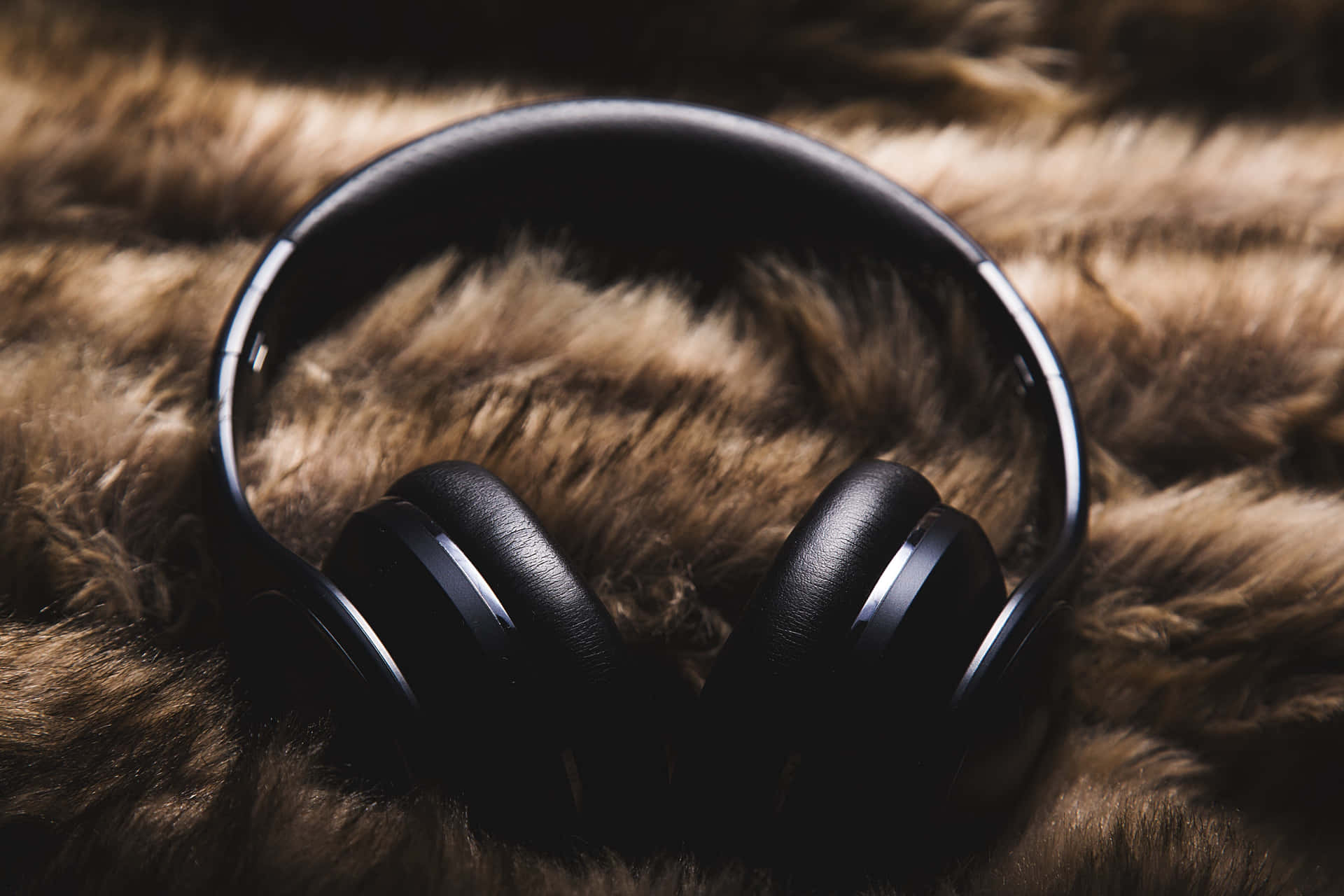 A Pair Of Headphones On A Furry Surface Background