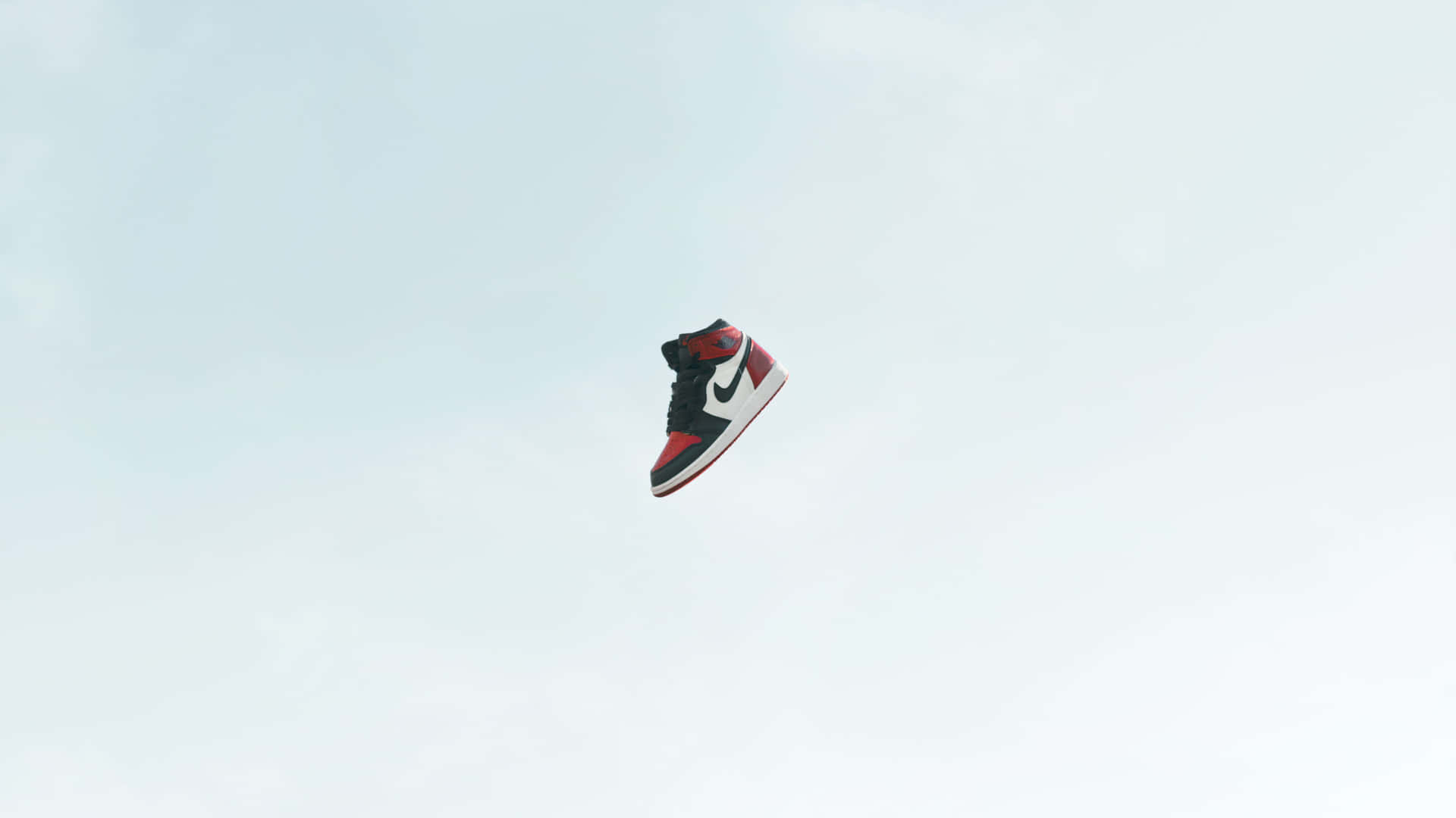 A Pair Of Sneakers Flying Through The Air Background