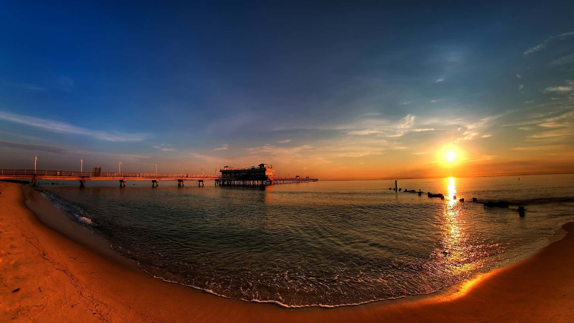 A Panoramic Desktop Background With A Beach And A Pier