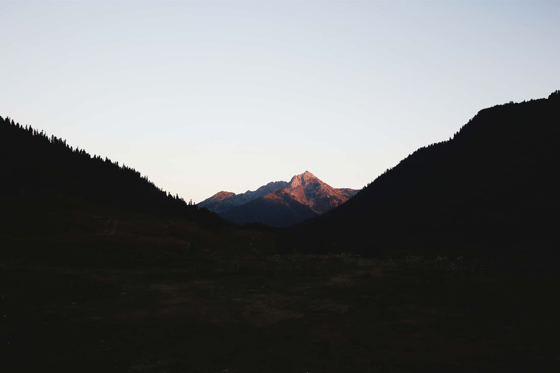 A Peaceful Vista Of A Minimalist Mountain Rises Into A Beautiful Blue Sky Background