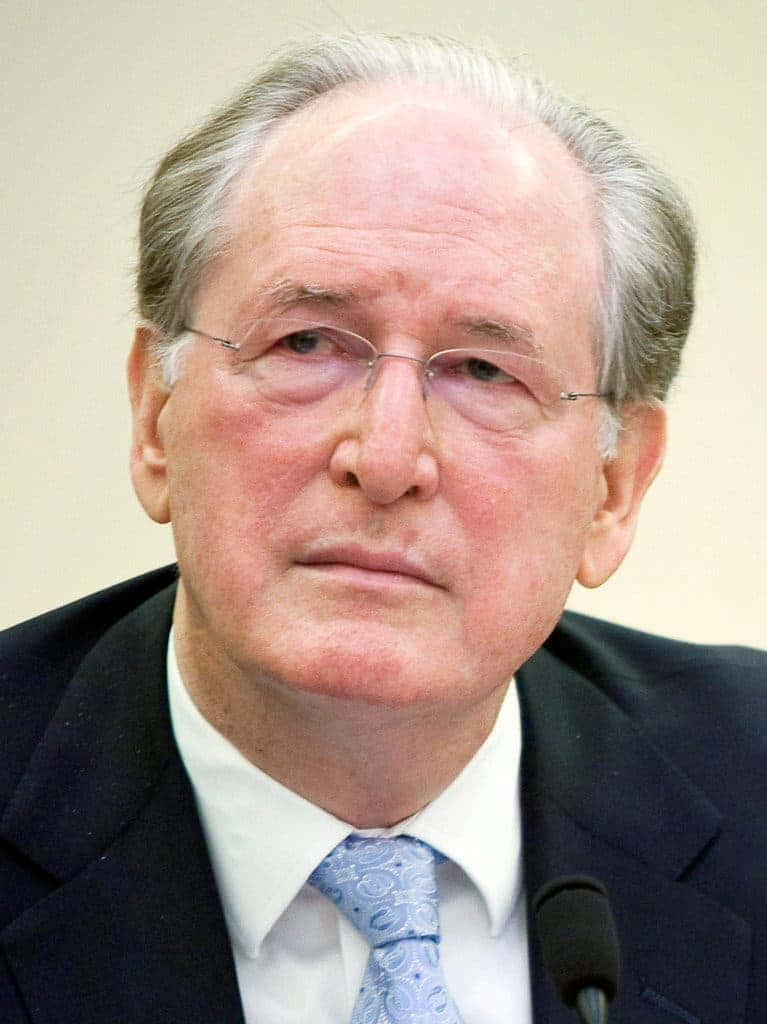 A Pensive Jay Rockefeller Engaging In A Conversation Background