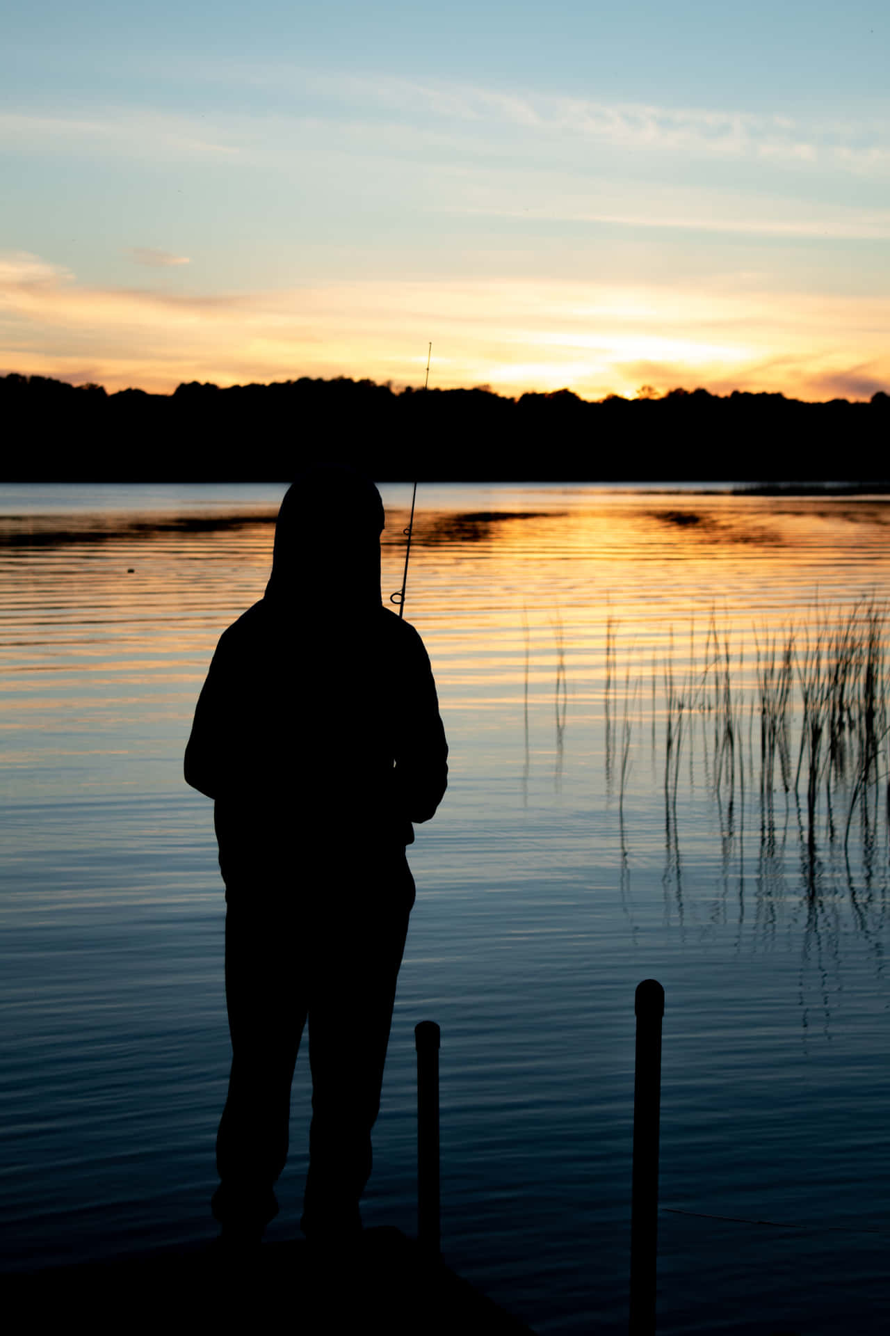 A Person Fishing On A Dock