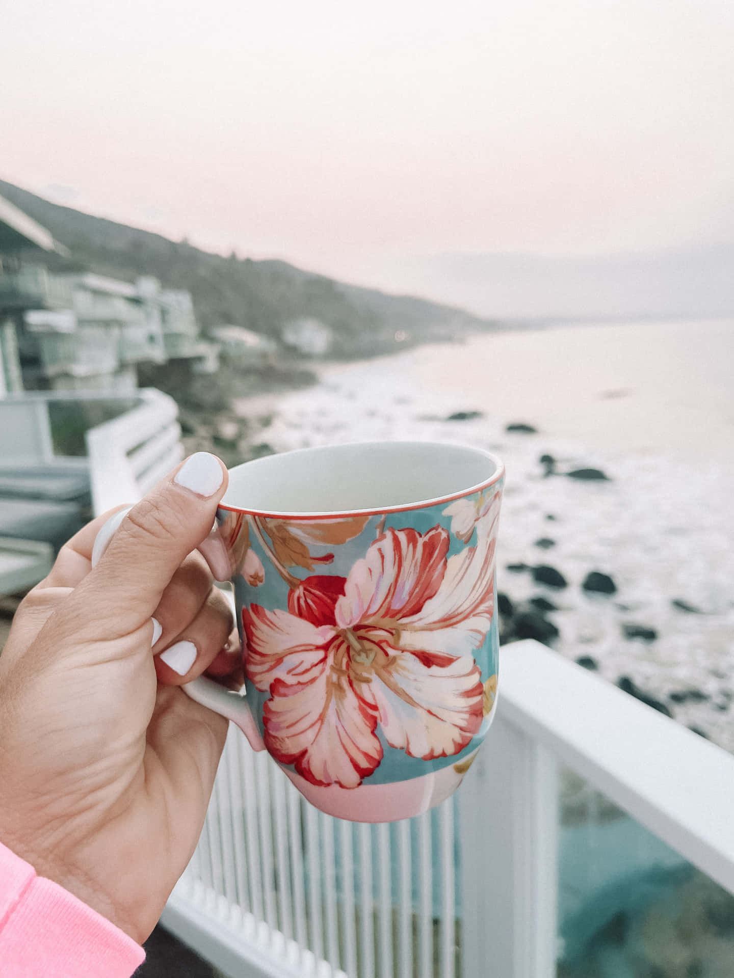 A Person Holding A Coffee Mug With A Flower On It Background