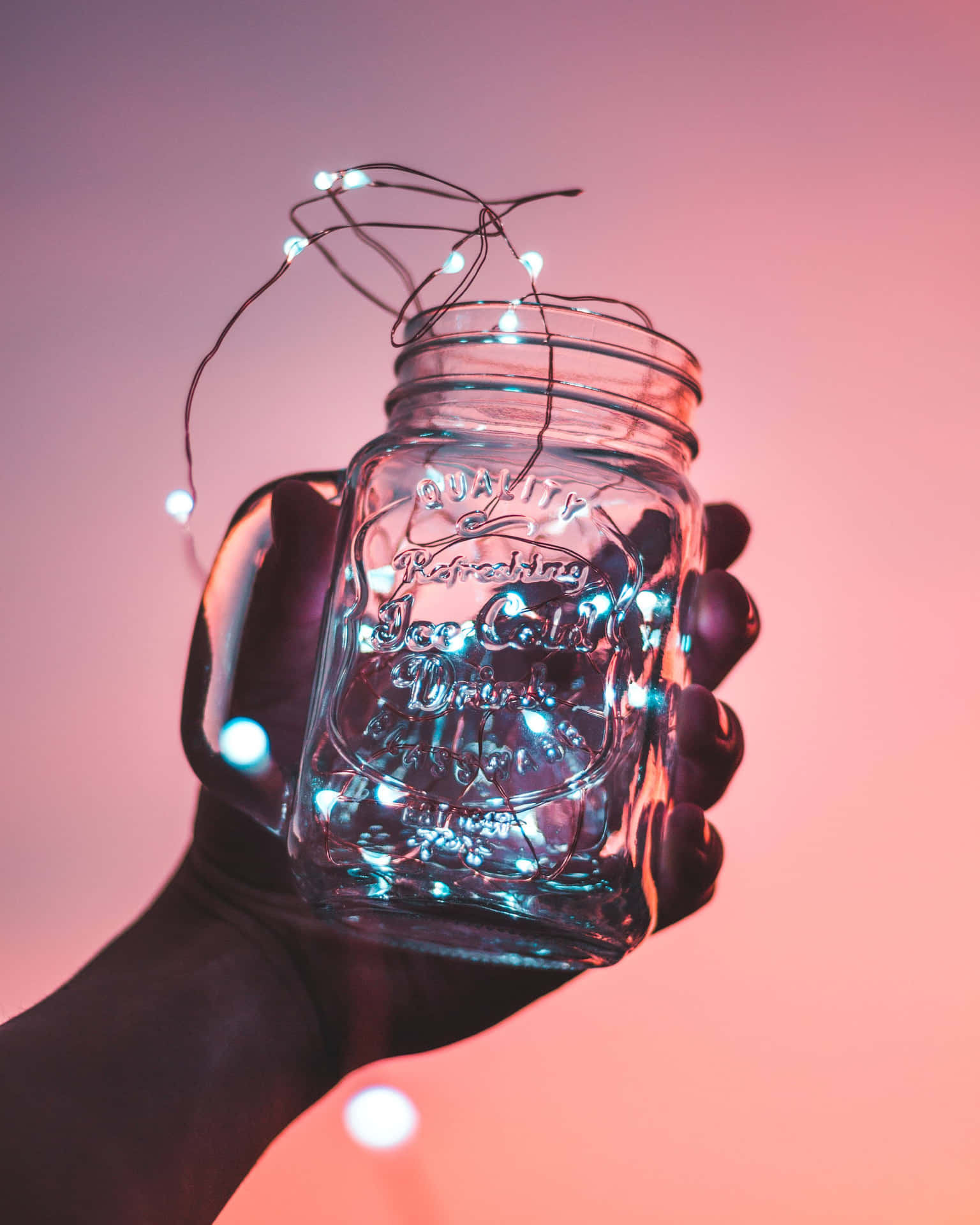 A Person Holding A Jar Of Lights Background