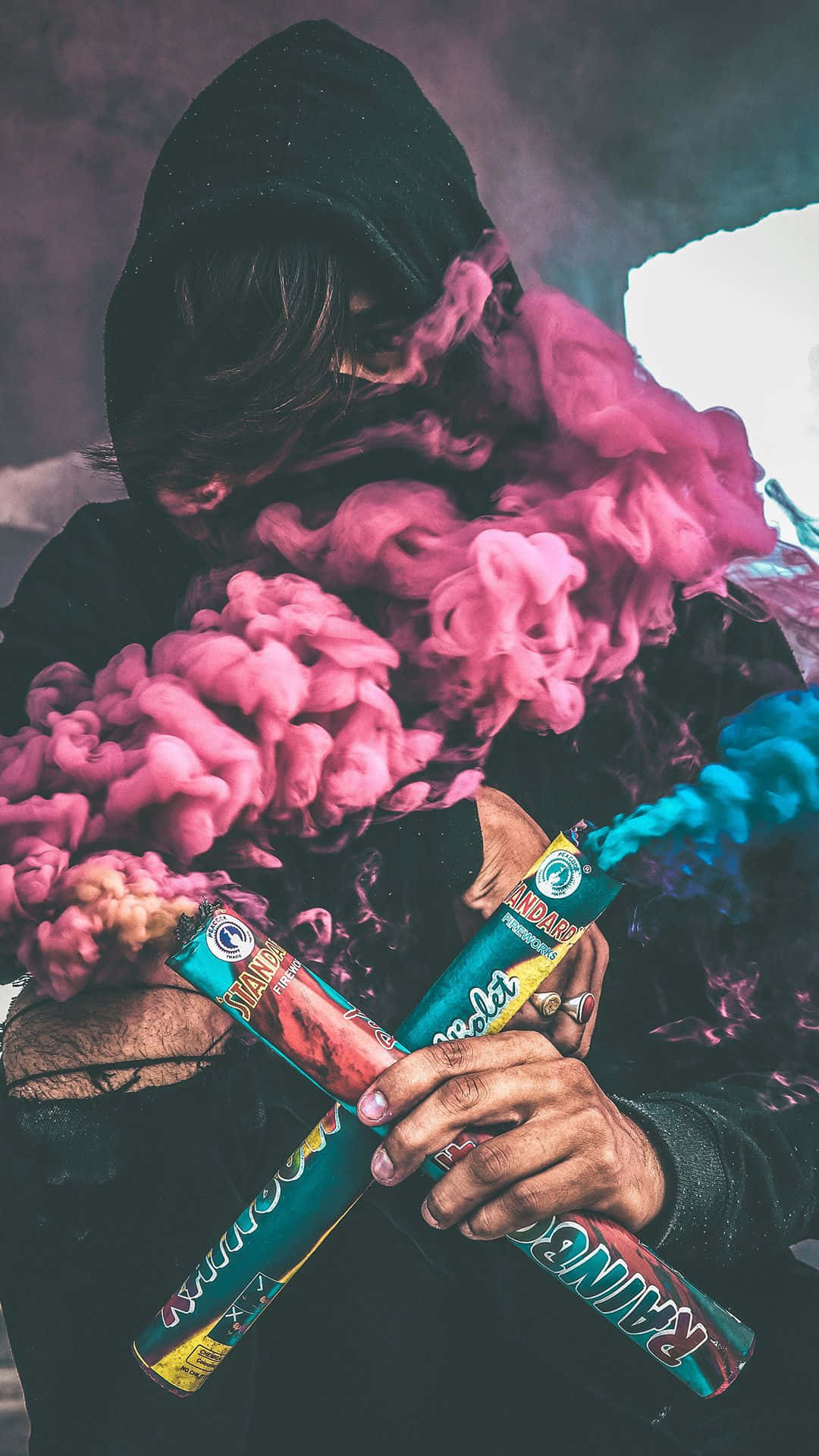 A Person Holding A Pink And Blue Smoke Background