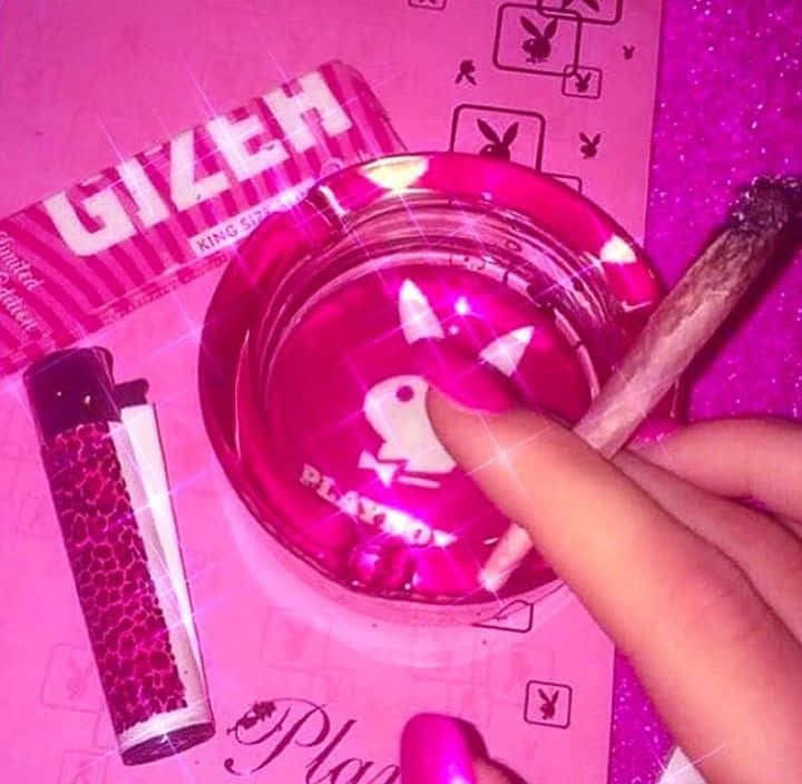 A Person Holding A Pink Ashtray And A Pink Cigarette Background