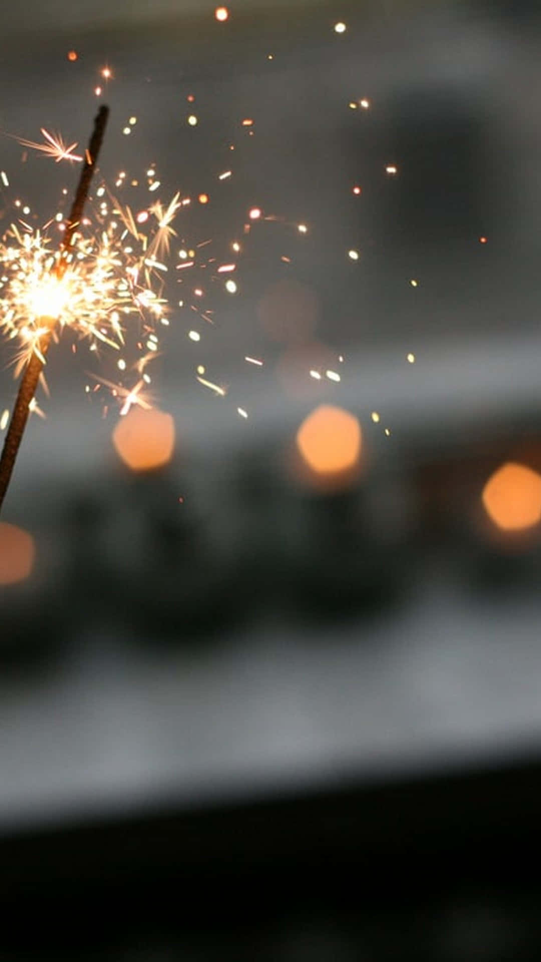 A Person Holding A Sparkler In Front Of Candles Background