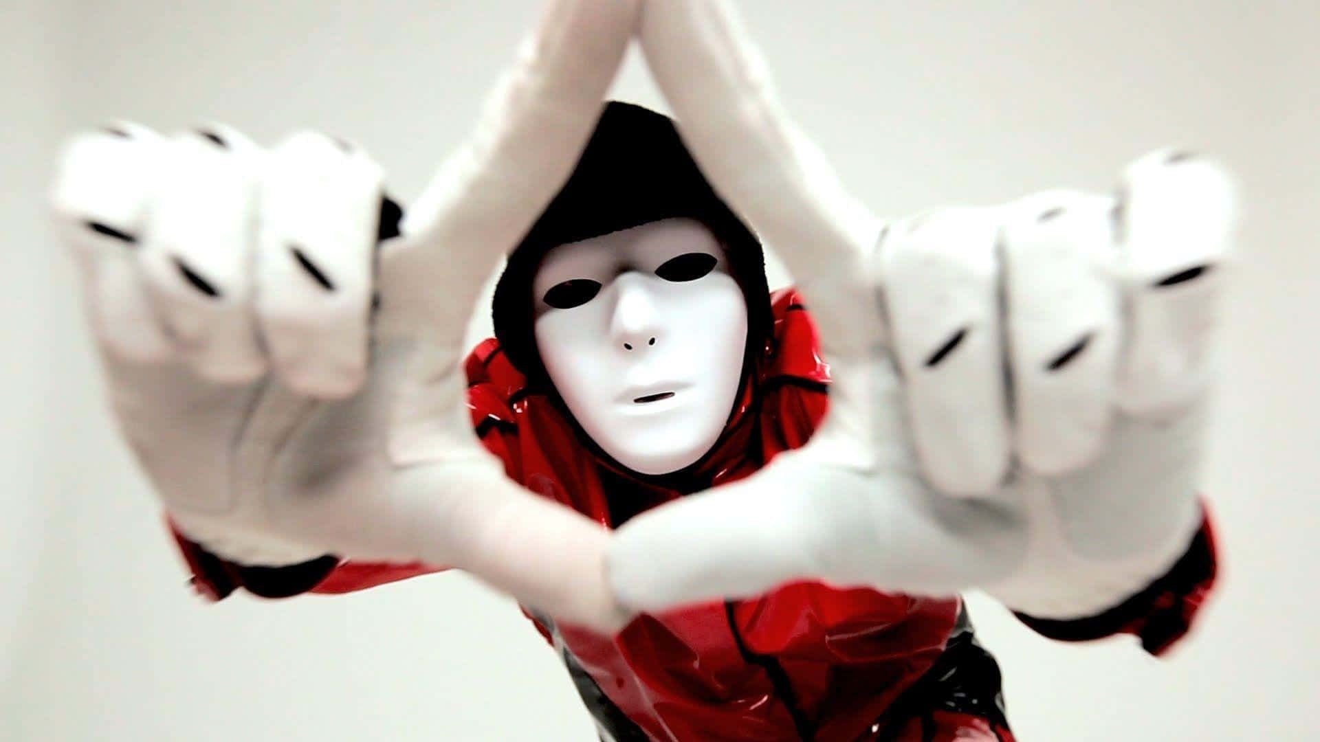 A Person In A Red Mask Making A Hand Gesture