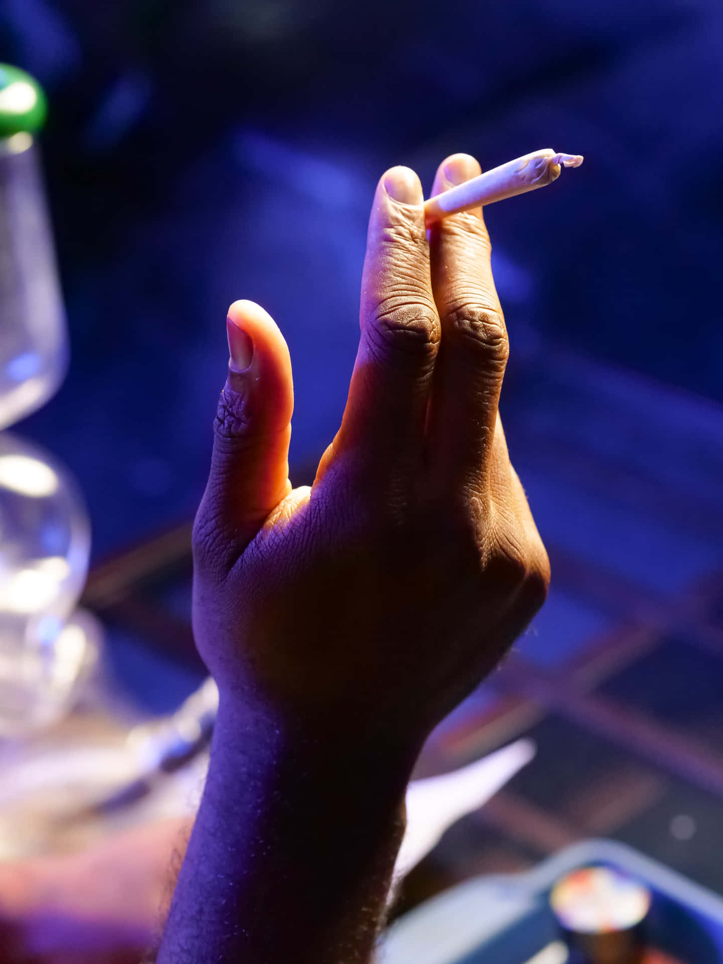 A Person Is Holding A Cigarette In Their Hand Background