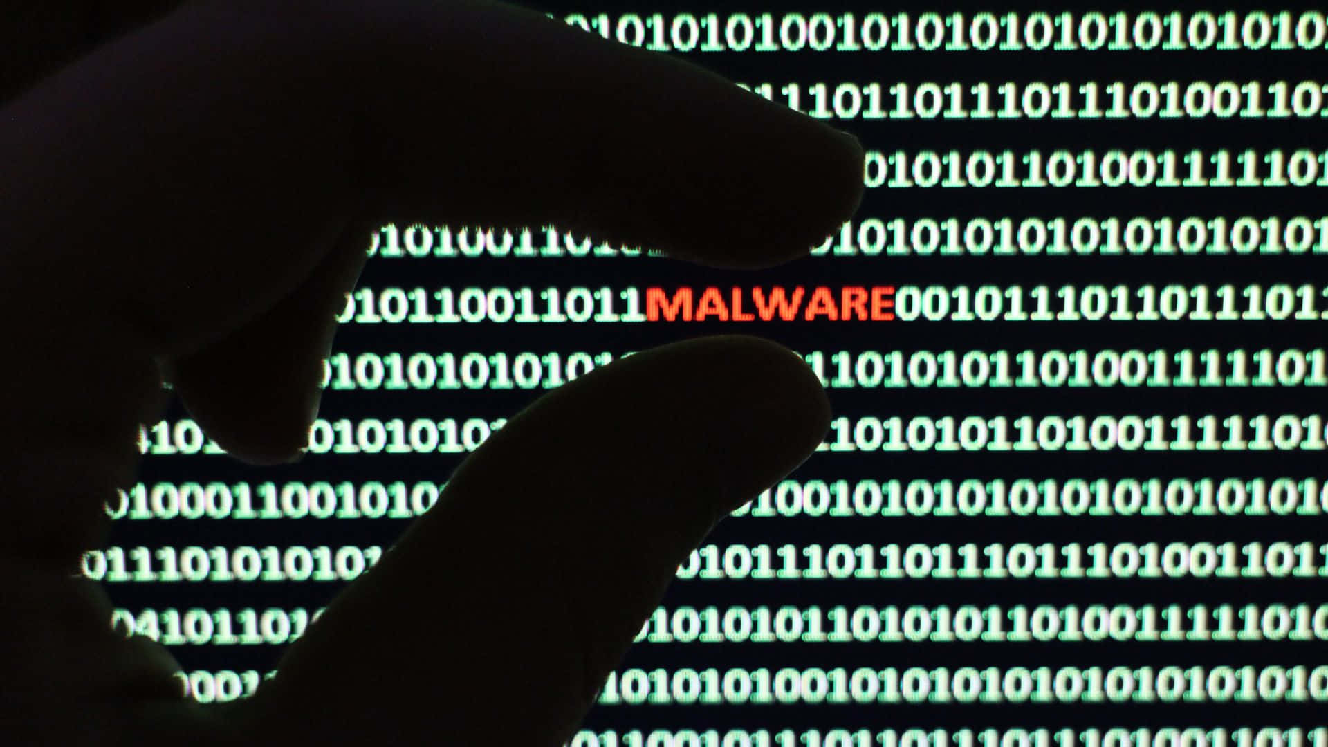 A Person Is Holding A Hand Up To A Computer Screen With The Word Malware Background