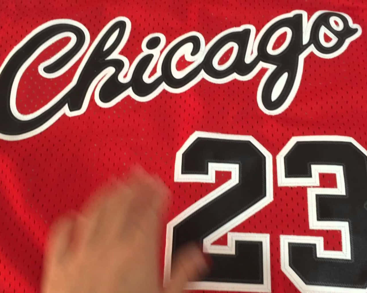 A Person Is Holding Up A Chicago Bulls Jersey Background