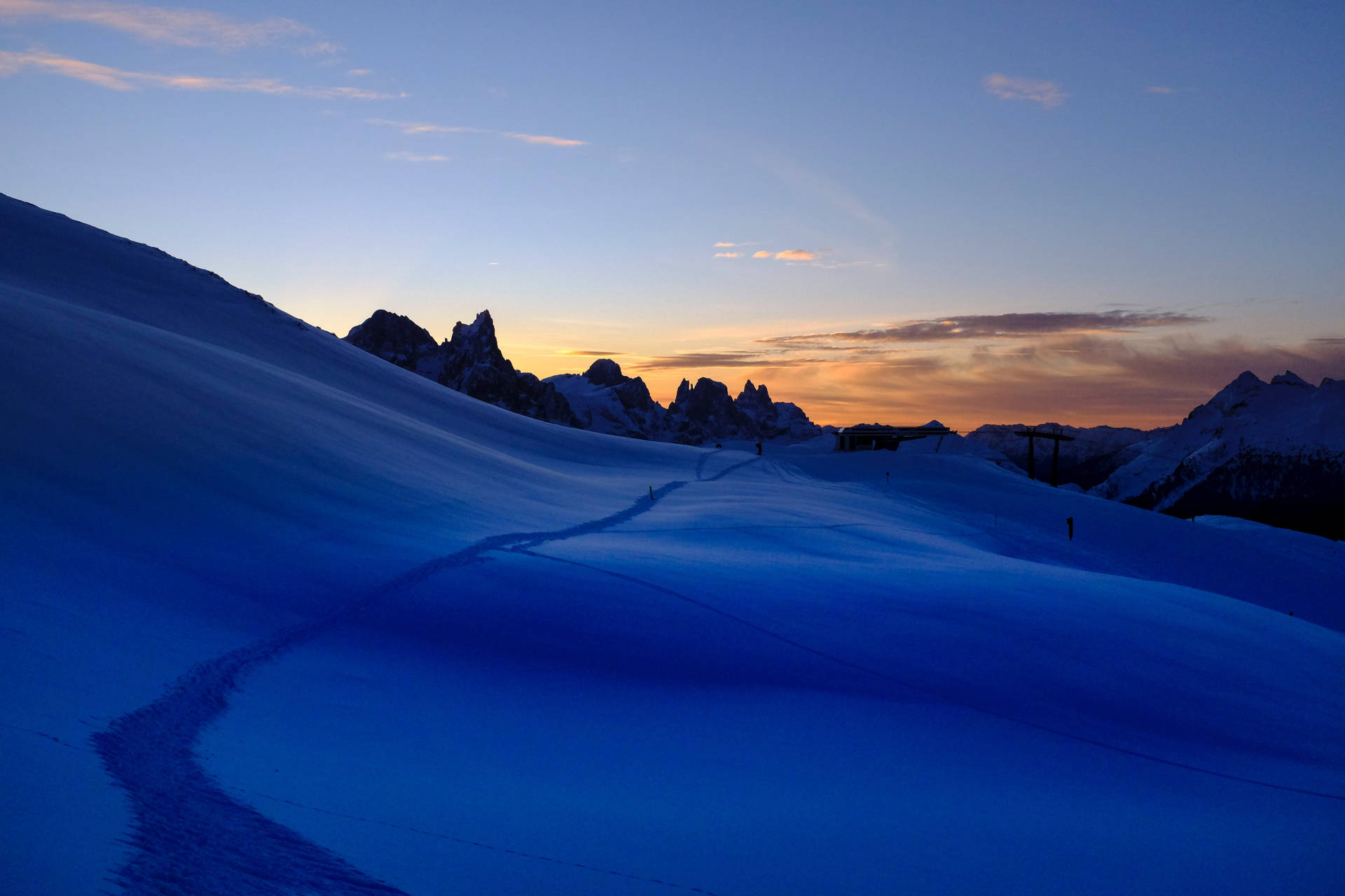 A Person Is Skiing Down A Snow Covered Mountain Background