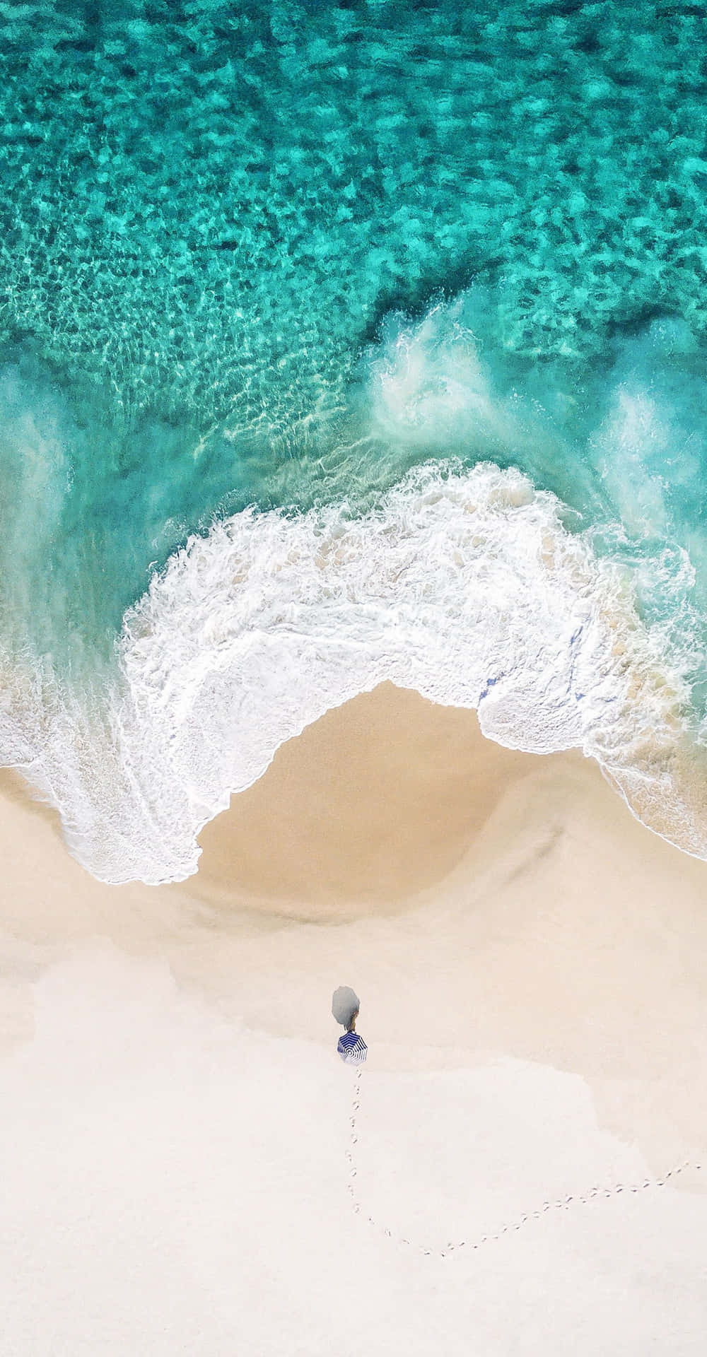 A Person Is Standing On A Beach With A Umbrella Background