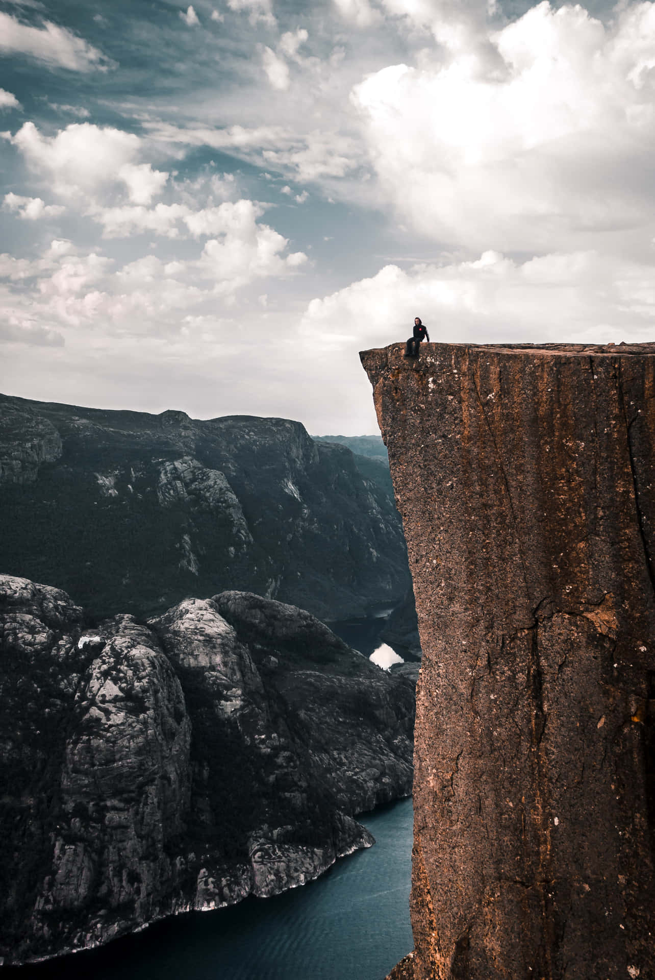 A Person Is Standing On A Cliff Background