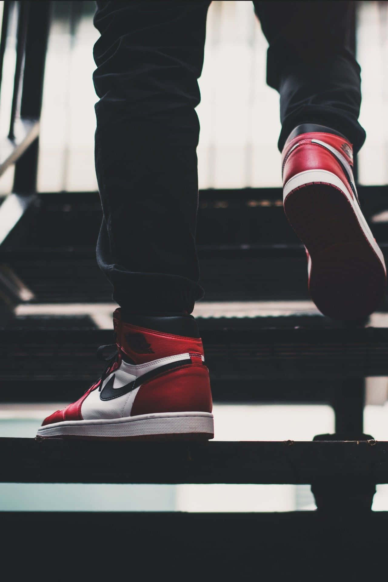 A Person Is Standing On Stairs Wearing Red And White Sneakers Background