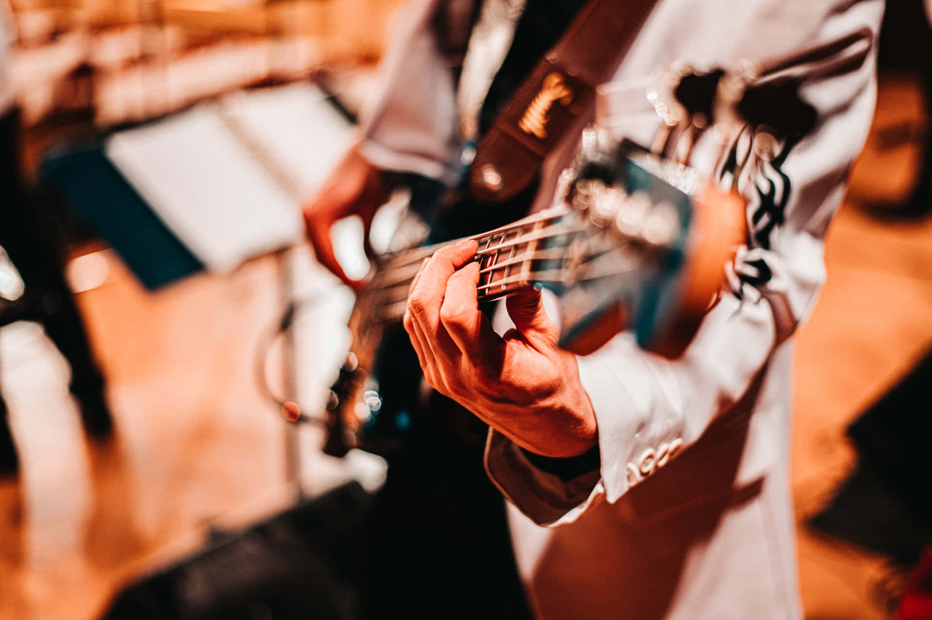 A Person Playing A Bass Guitar In A Concert