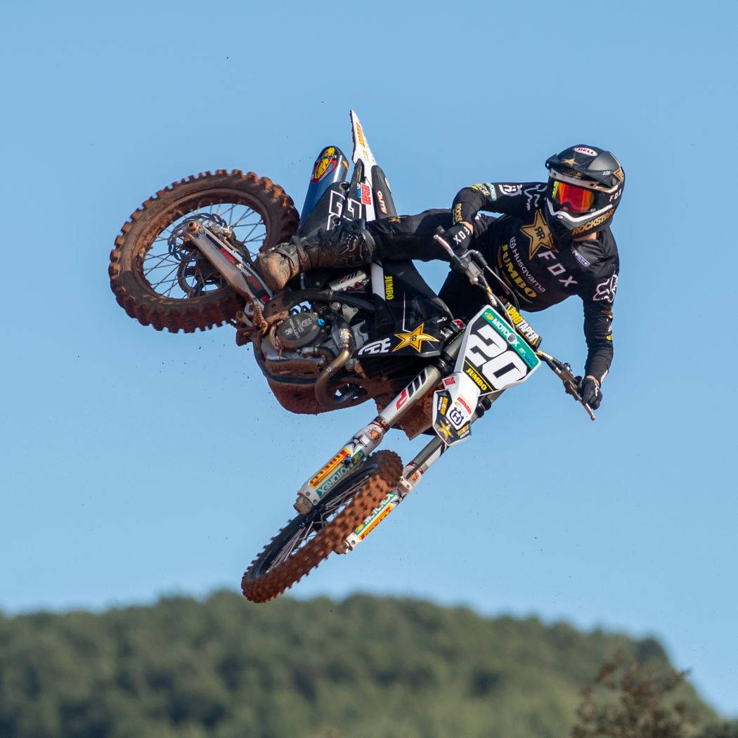 A Person Riding A Dirt Bike In The Air Background