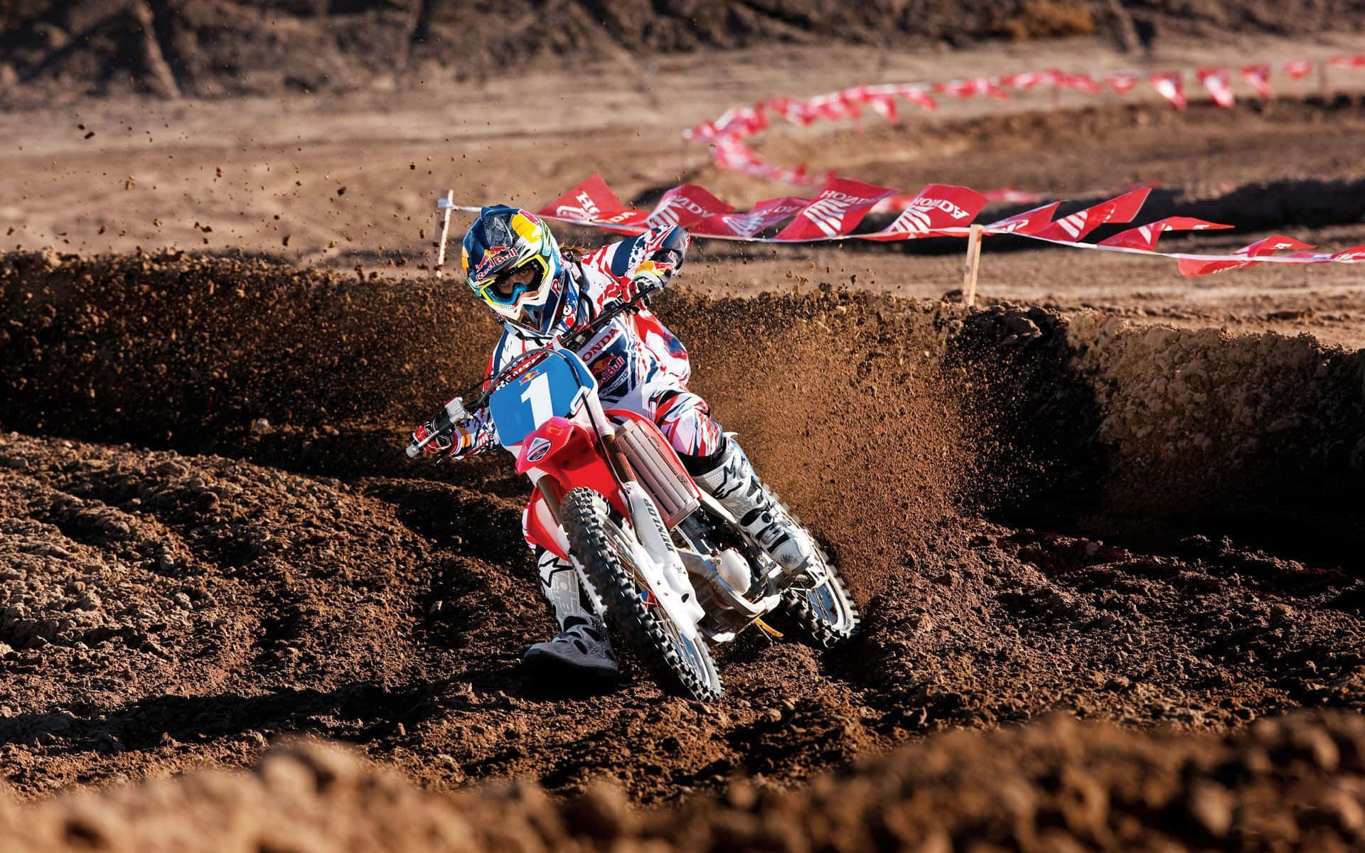 A Person Riding A Dirt Bike On A Dirt Track Background