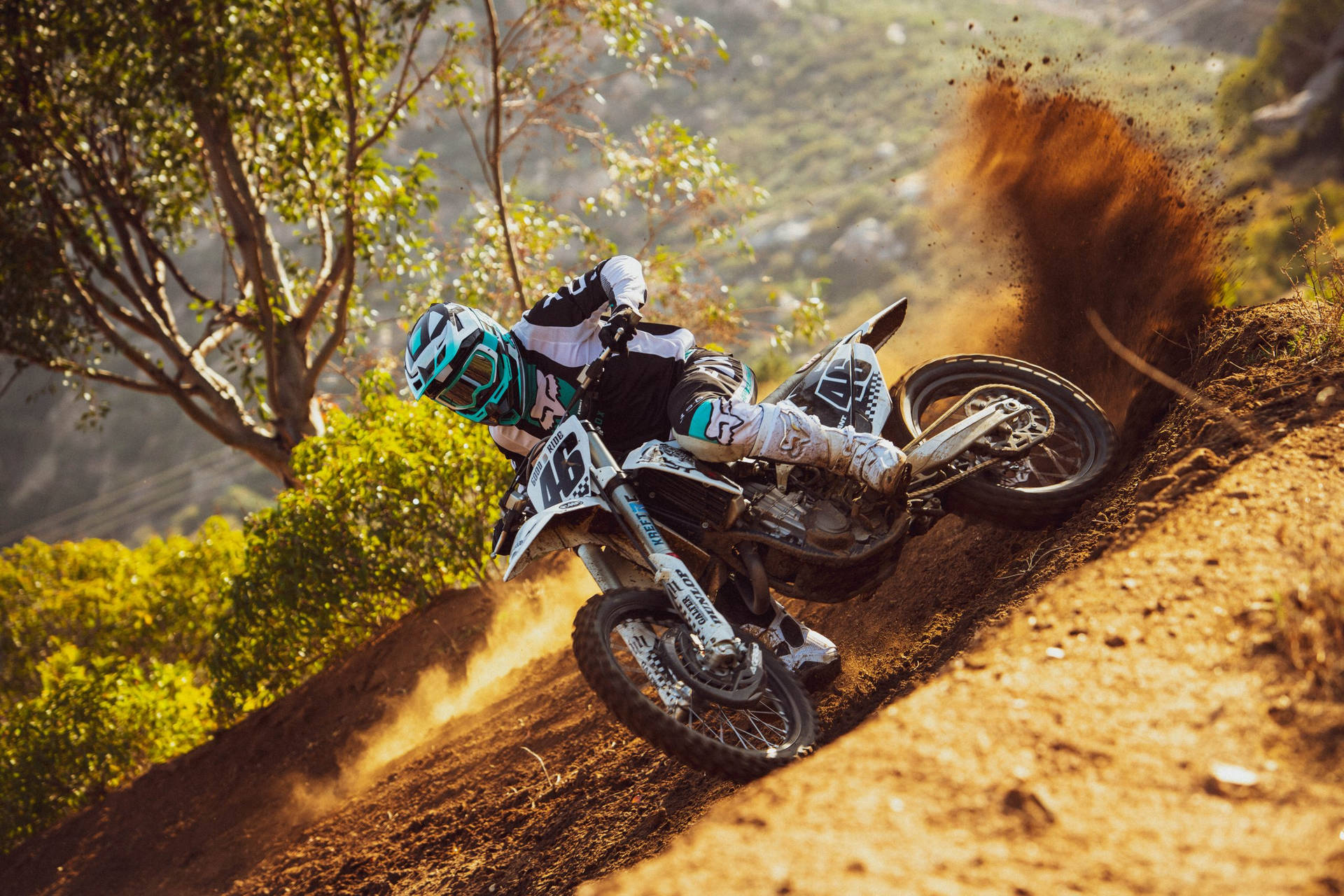 A Person Riding A Dirt Bike On A Dirt Track Background