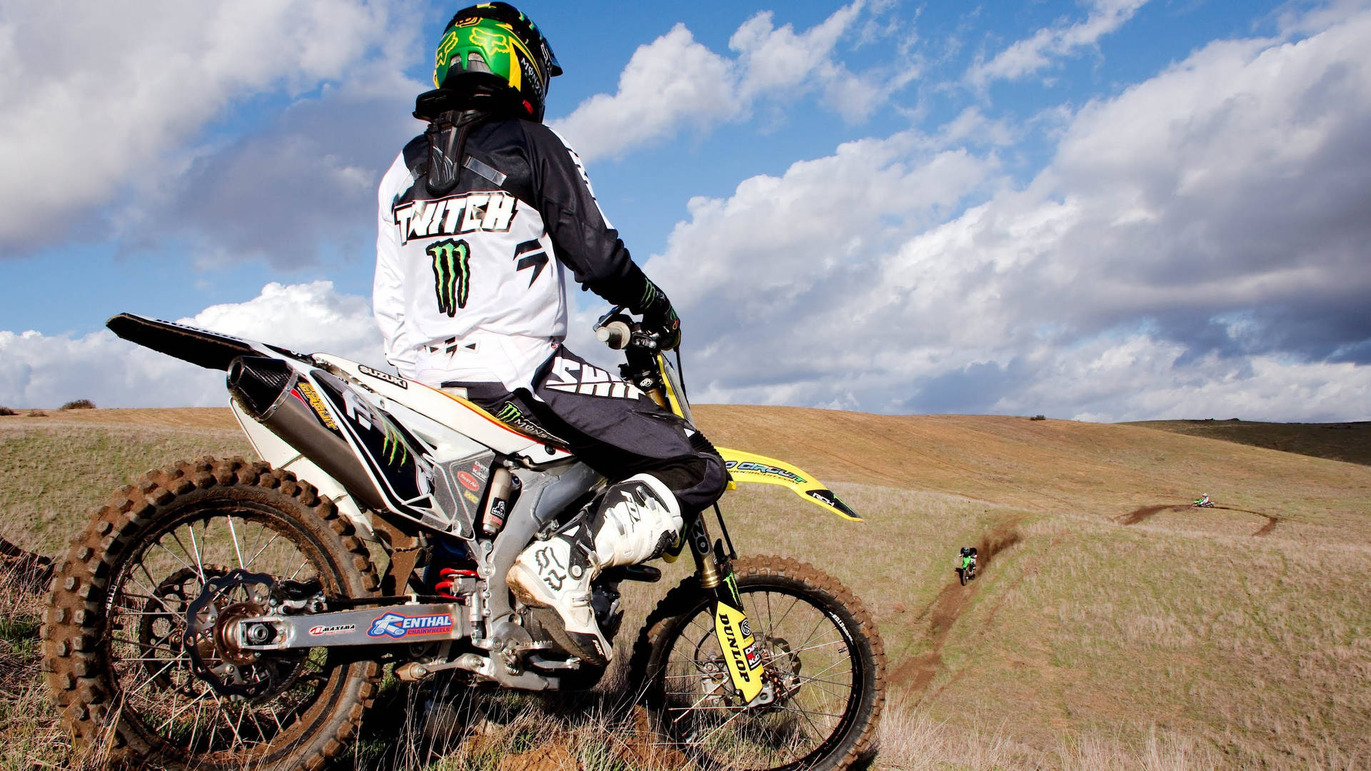 A Person Riding A Dirt Bike On A Hill Background