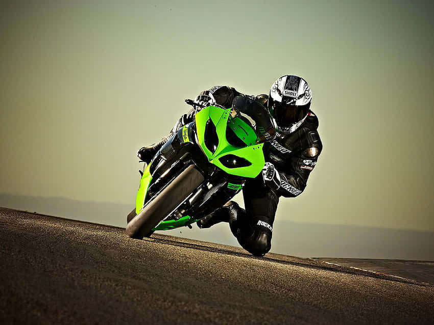 A Person Riding A Green Motorcycle On A Hill Background