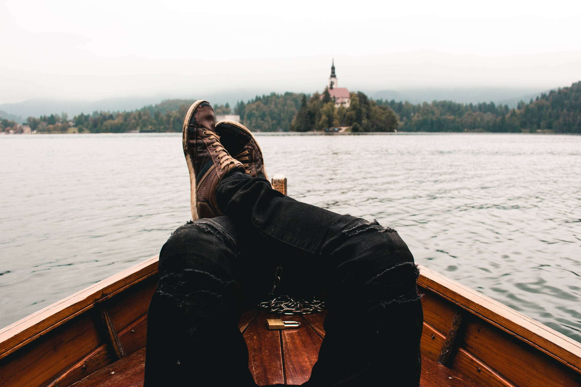 A Person's Feet Are Resting On The Back Of A Boat Background