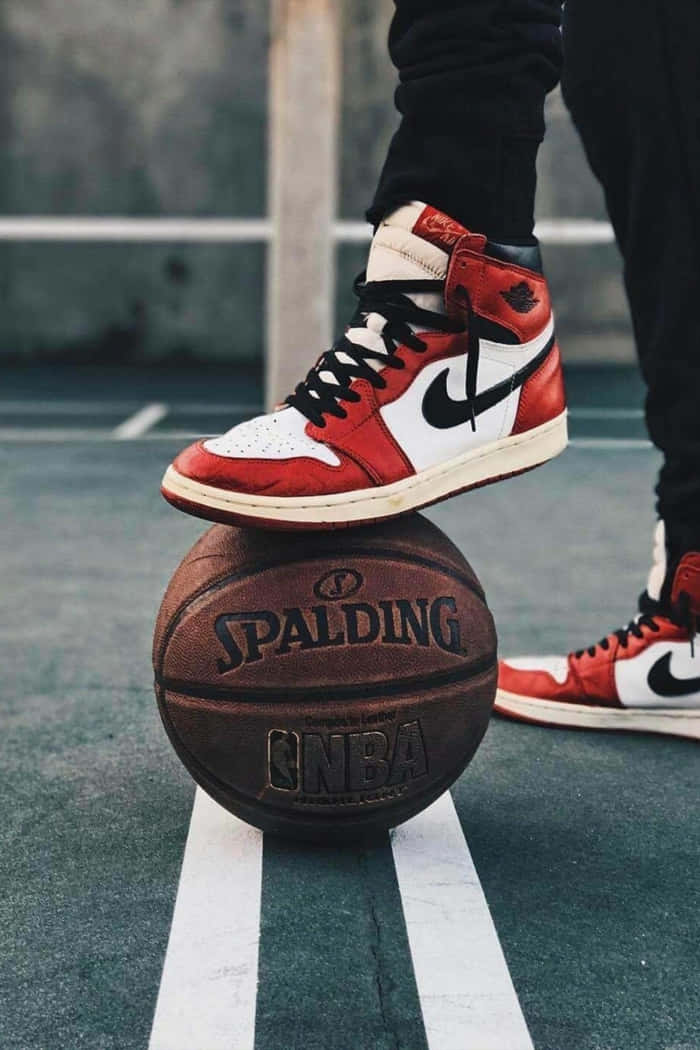 A Person Standing On A Basketball Court With A Pair Of Air Jordans