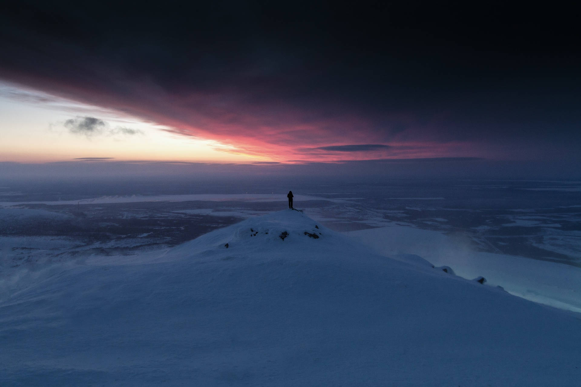 A Person Standing On Top Of A Snow Covered Mountain Background