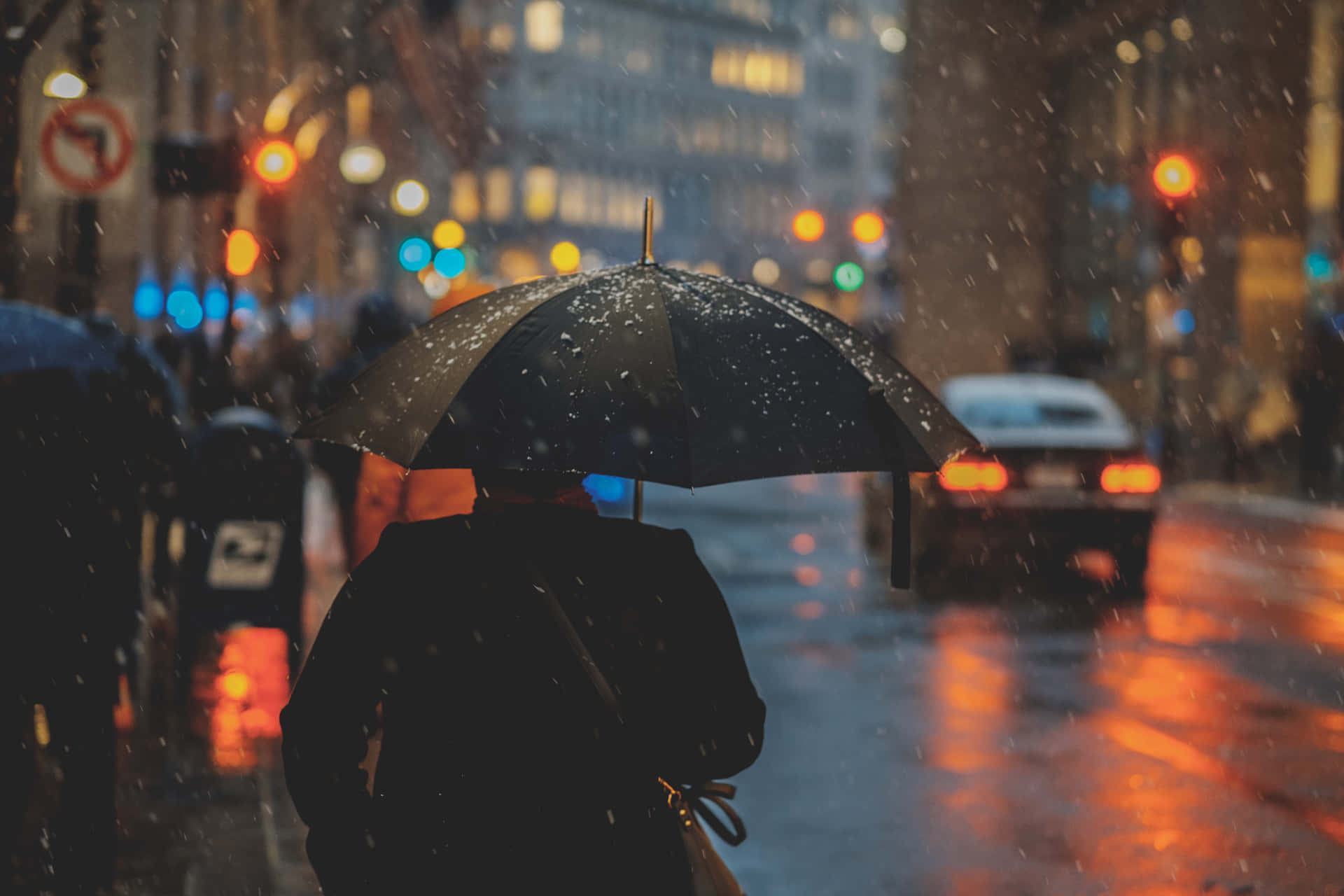 A Person Walking Down A City Street With An Umbrella