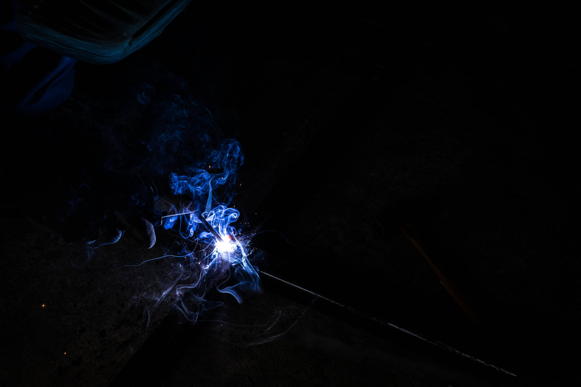 A Person Welding In The Dark Background
