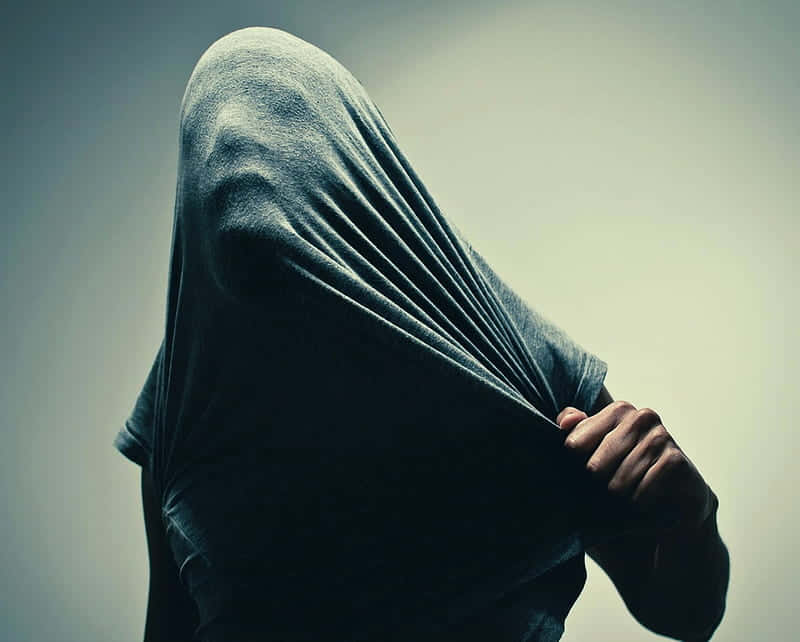 A Person With A Hood Covering Their Head Background