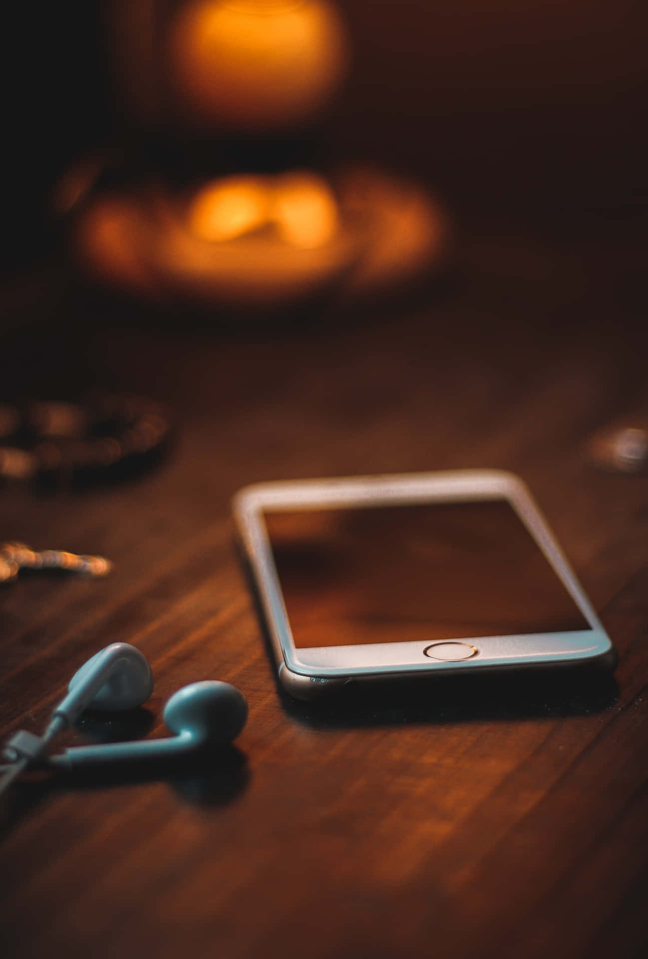 A Phone With Headphones On A Table Background