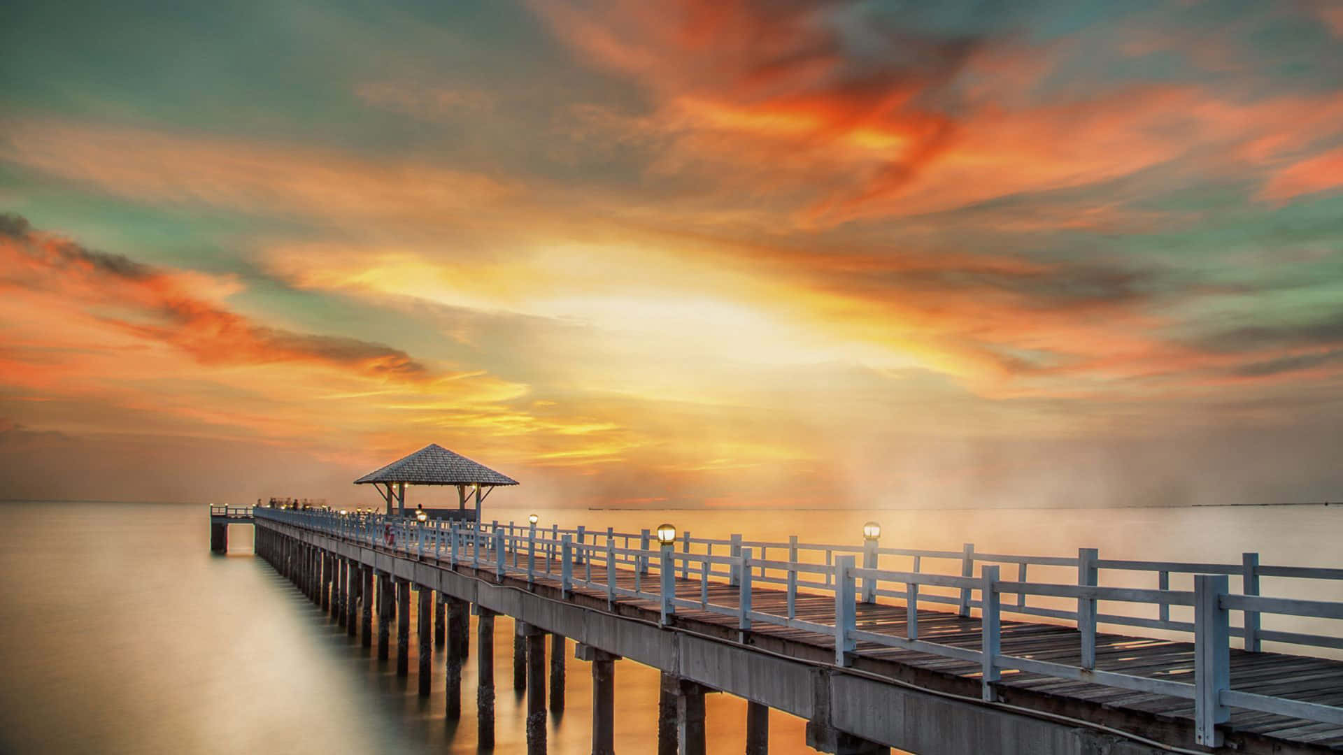 A Pier With A Gazebo In The Water Background