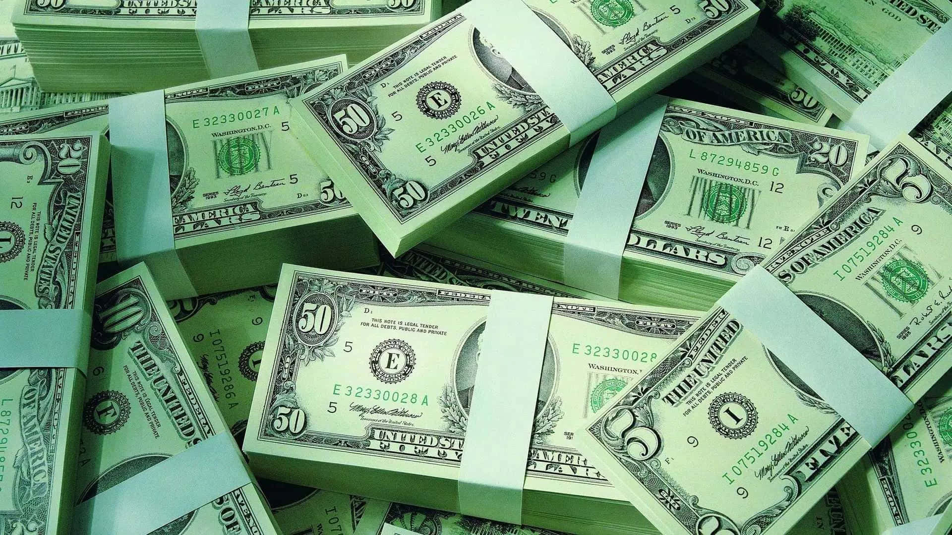 A Pile Of Money With Green Tape Background