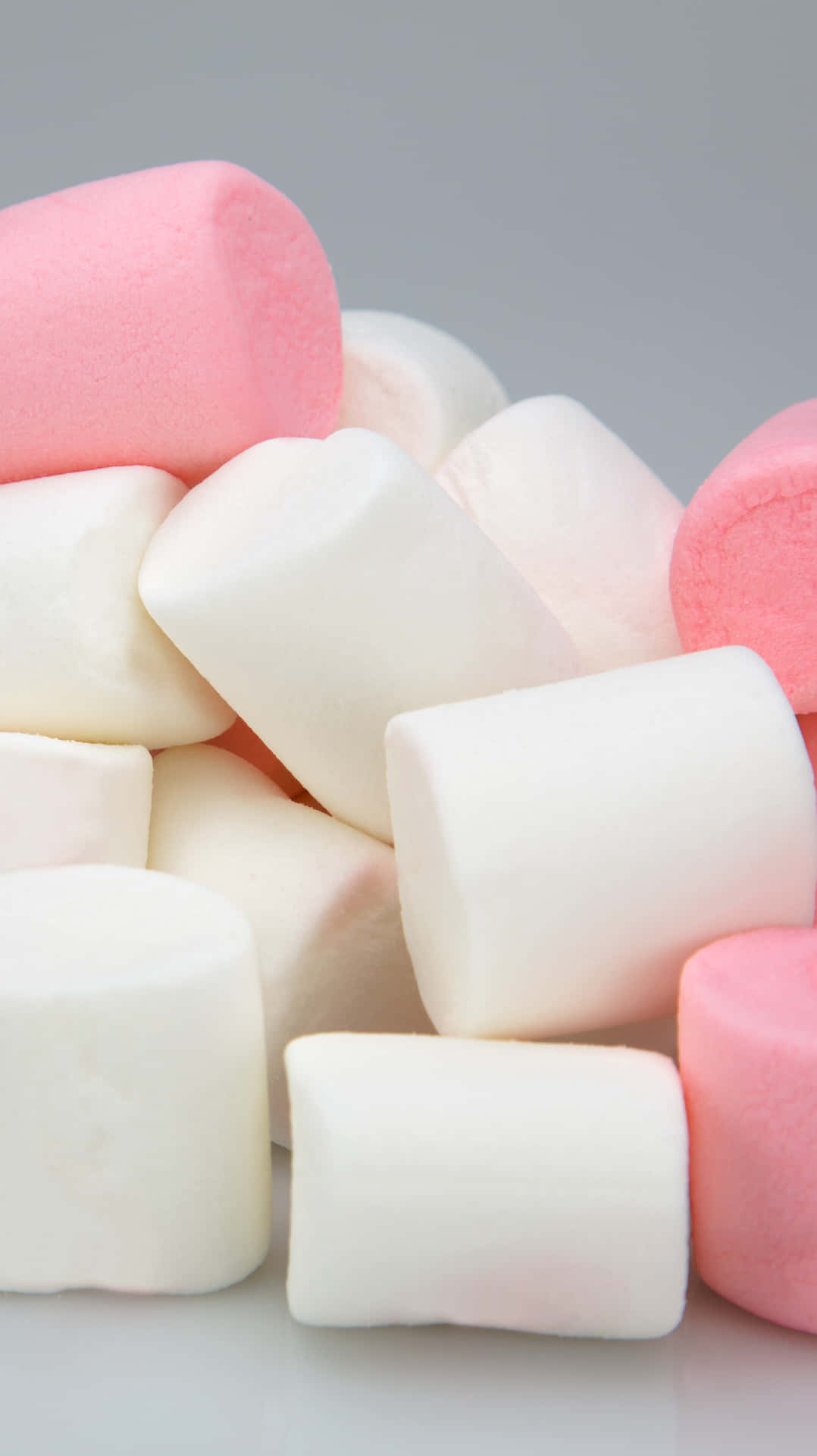 A Pile Of Pink And White Marshmallows On A Gray Background Background