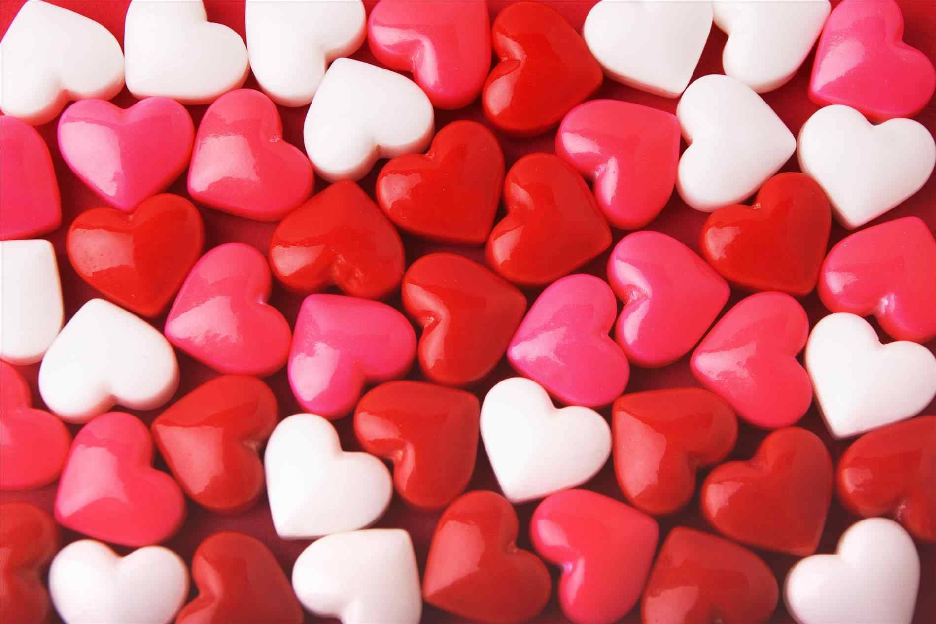 A Pile Of Red And White Heart Shaped Candy Background