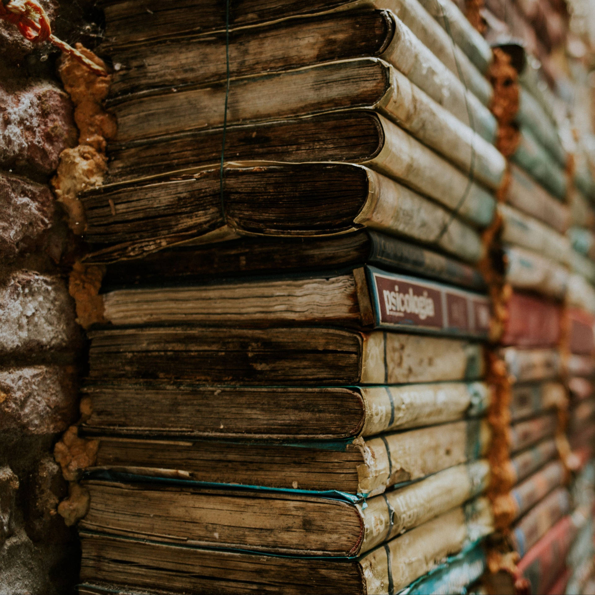 A Pile Of Vintage Books In A Library Background