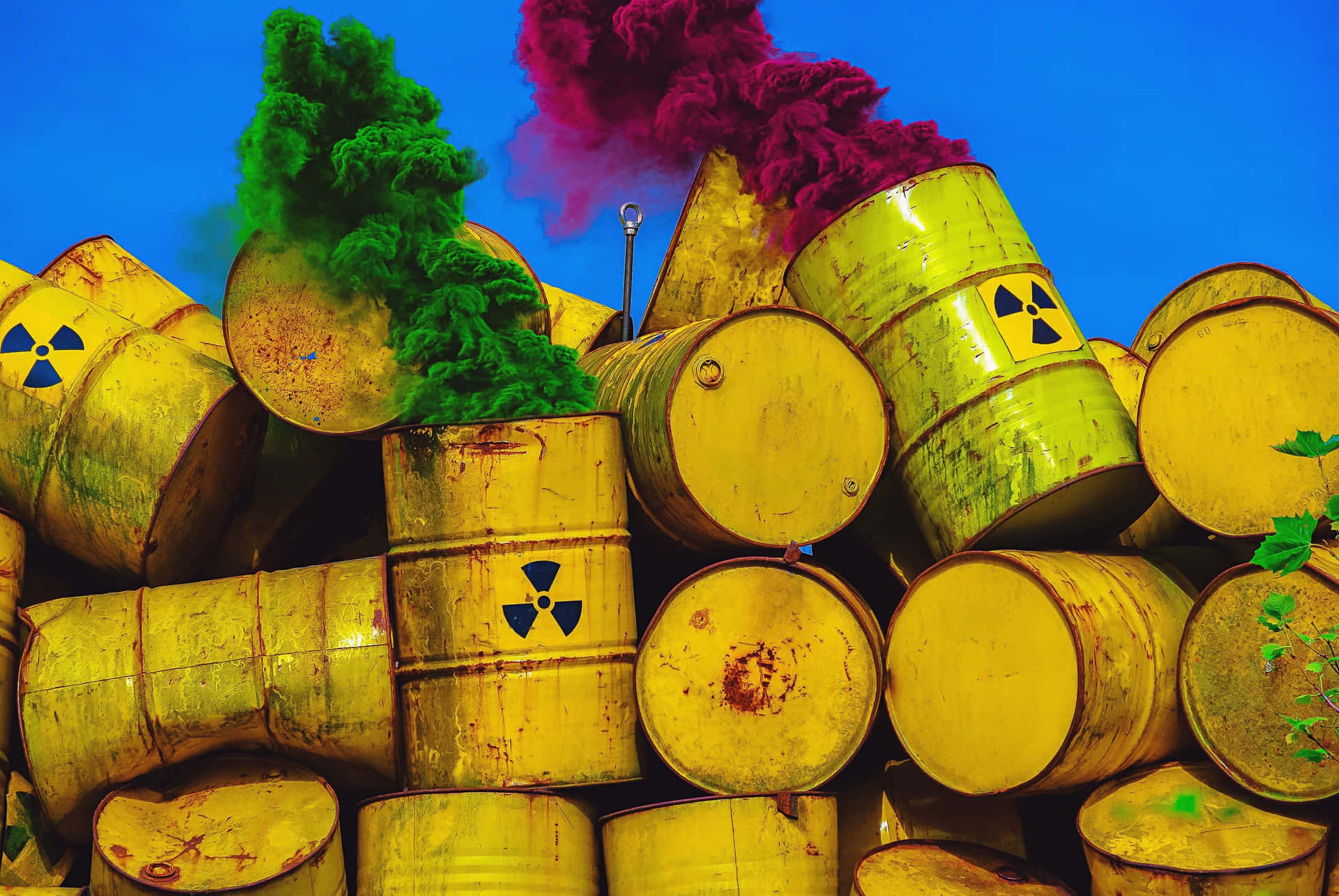 A Pile Of Yellow Barrels With Colored Smoke