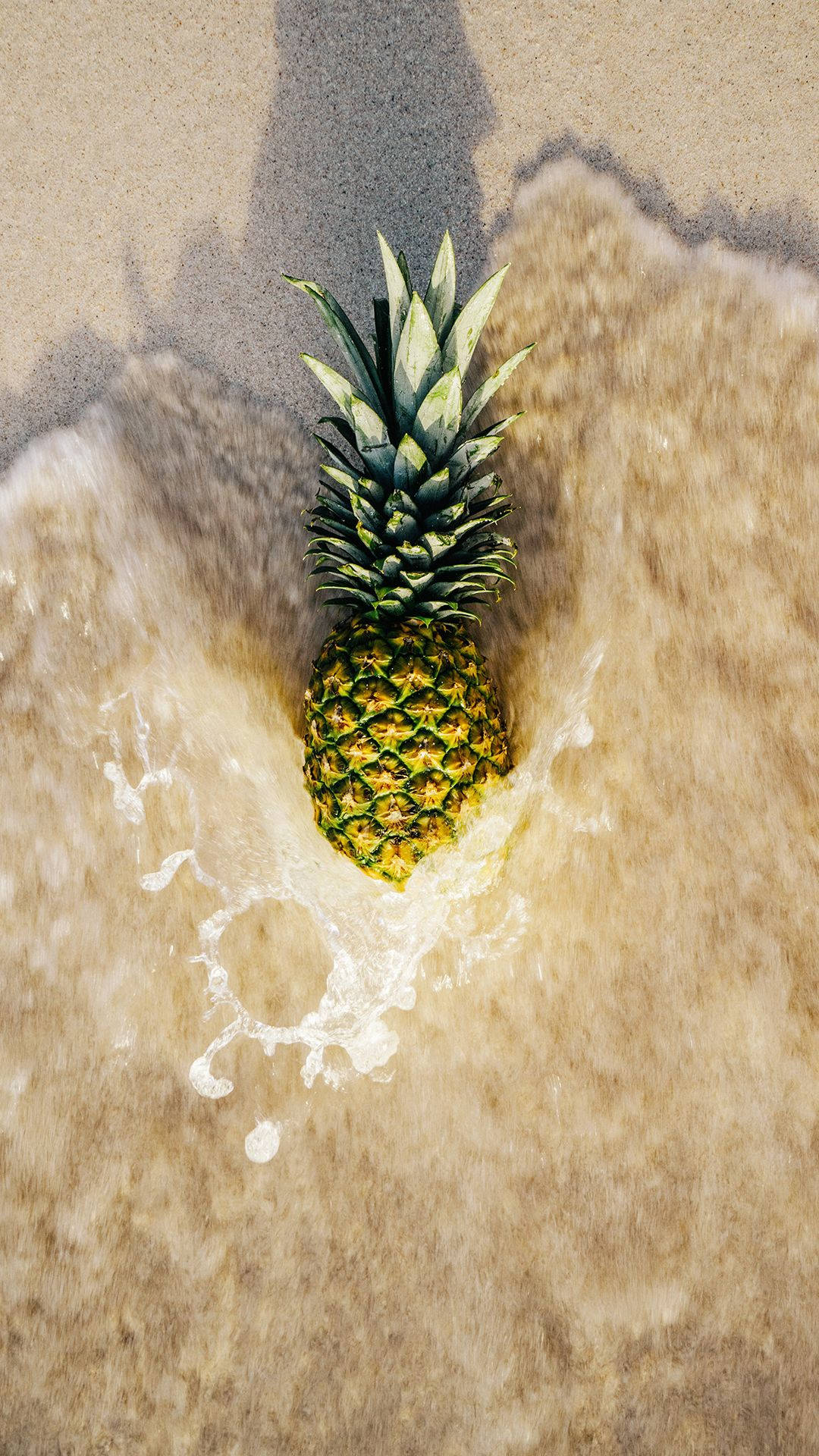 A Pineapple Being Bathed In Glistening Ocean Waves Background