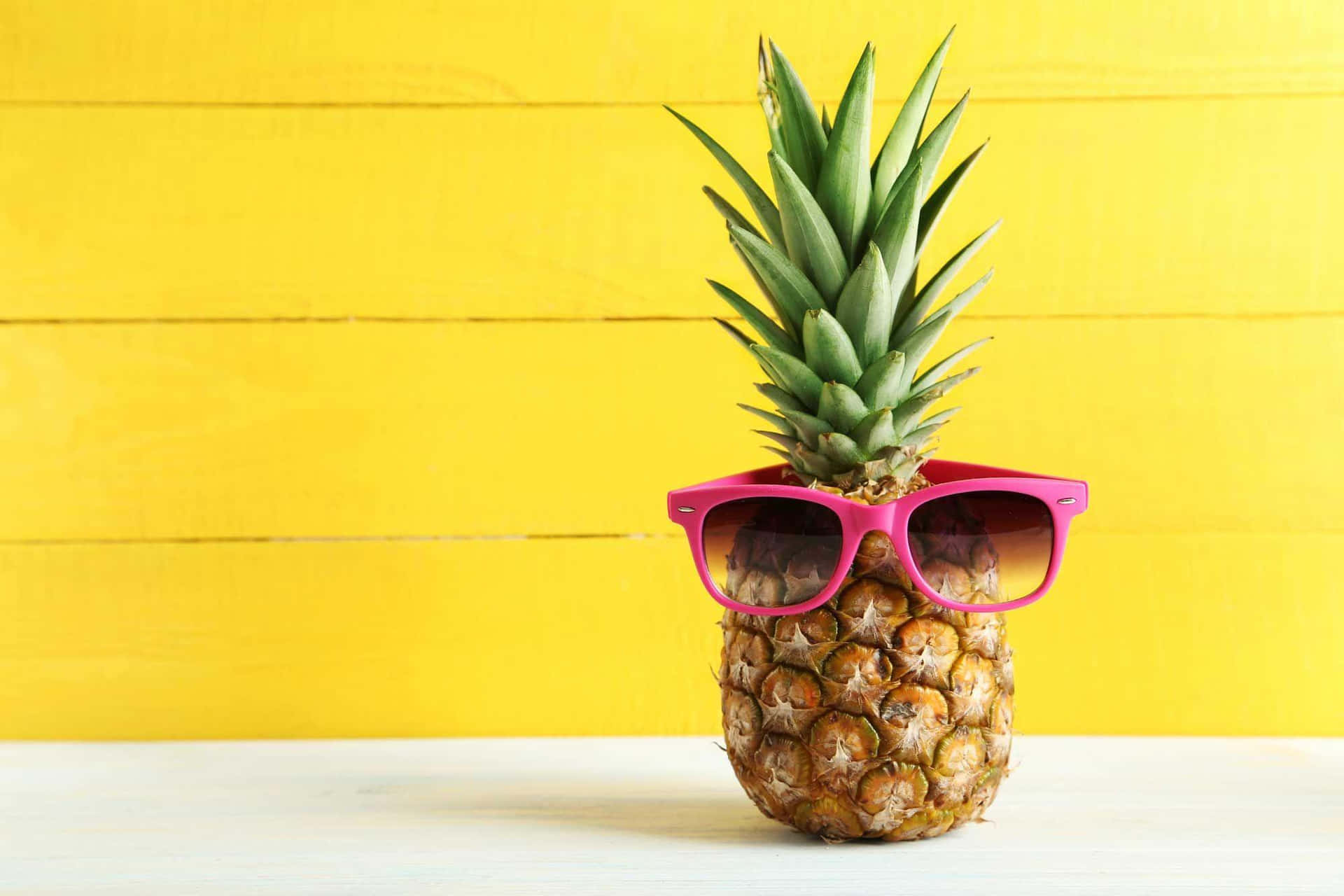 A Pineapple With Sunglasses On It On A Yellow Background Background