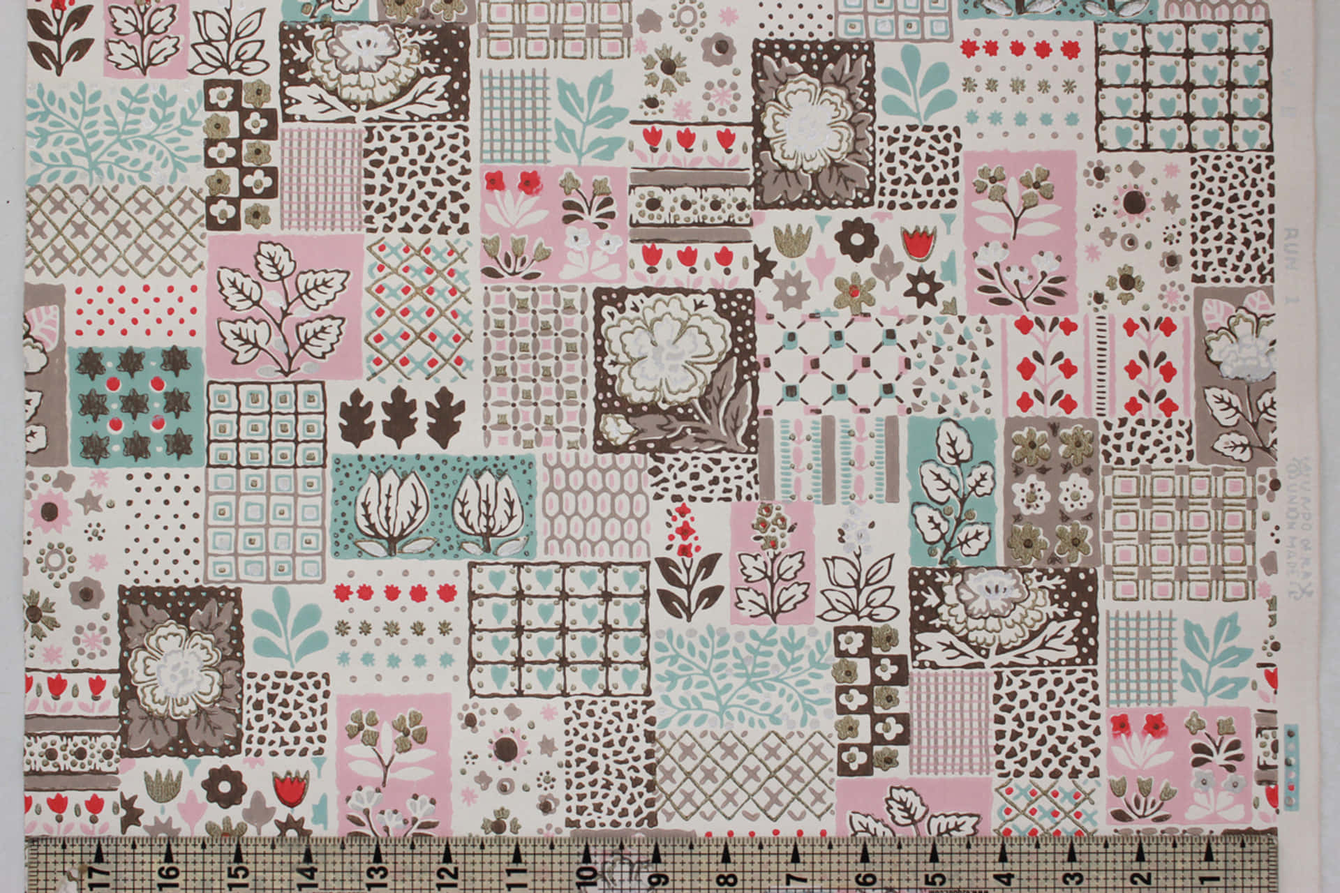 A Pink And Brown Quilt With A Ruler Background